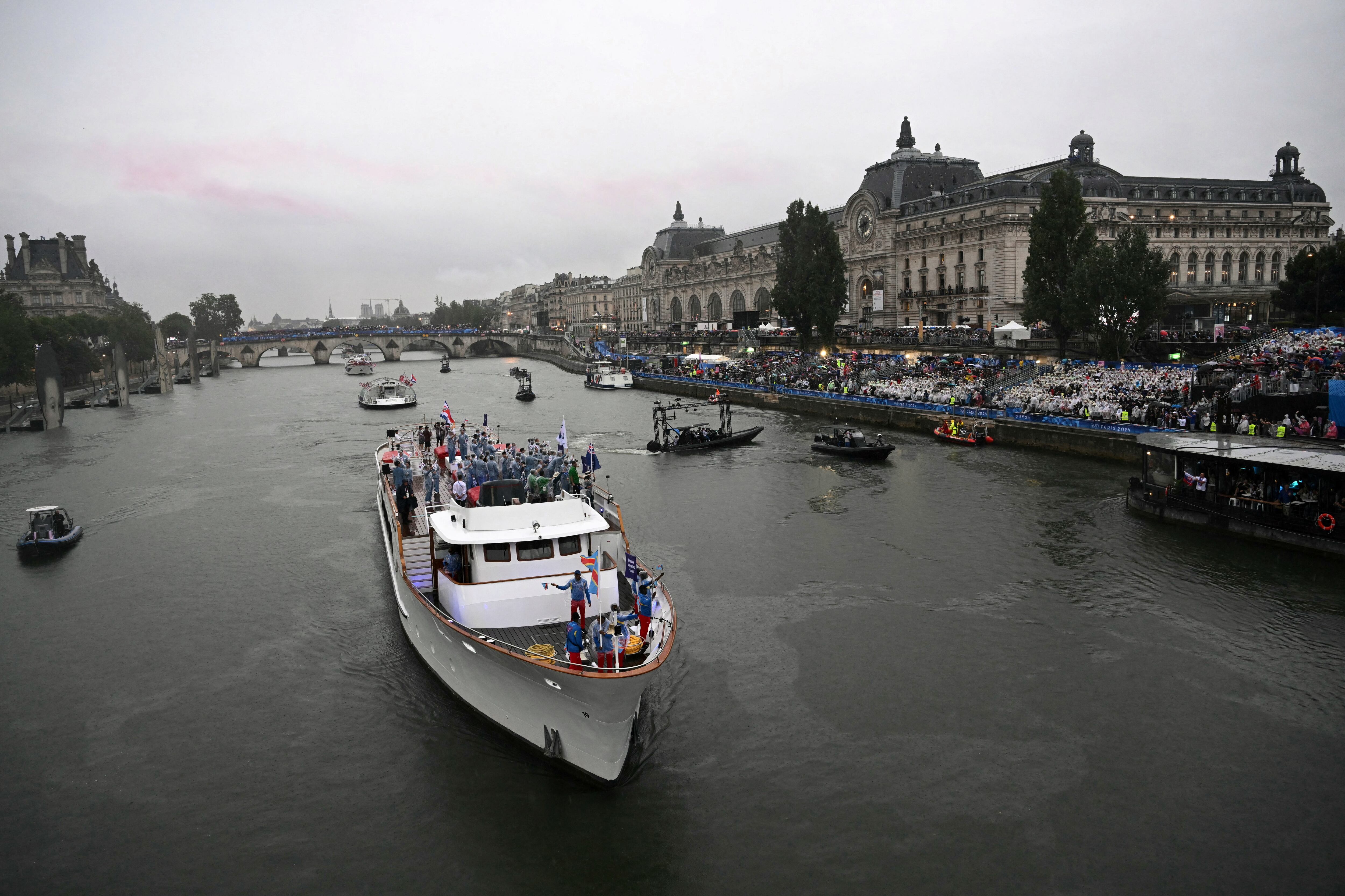 Atletas de las delegaciones de la República Democrática del Congo, las Islas Cook, la República de Corea, Costa Rica y Costa de Marfil navegan en un bote por el río Sena cerca del museo de Orsay durante la ceremonia de apertura de los Juegos Olímpicos de París 2024 en París