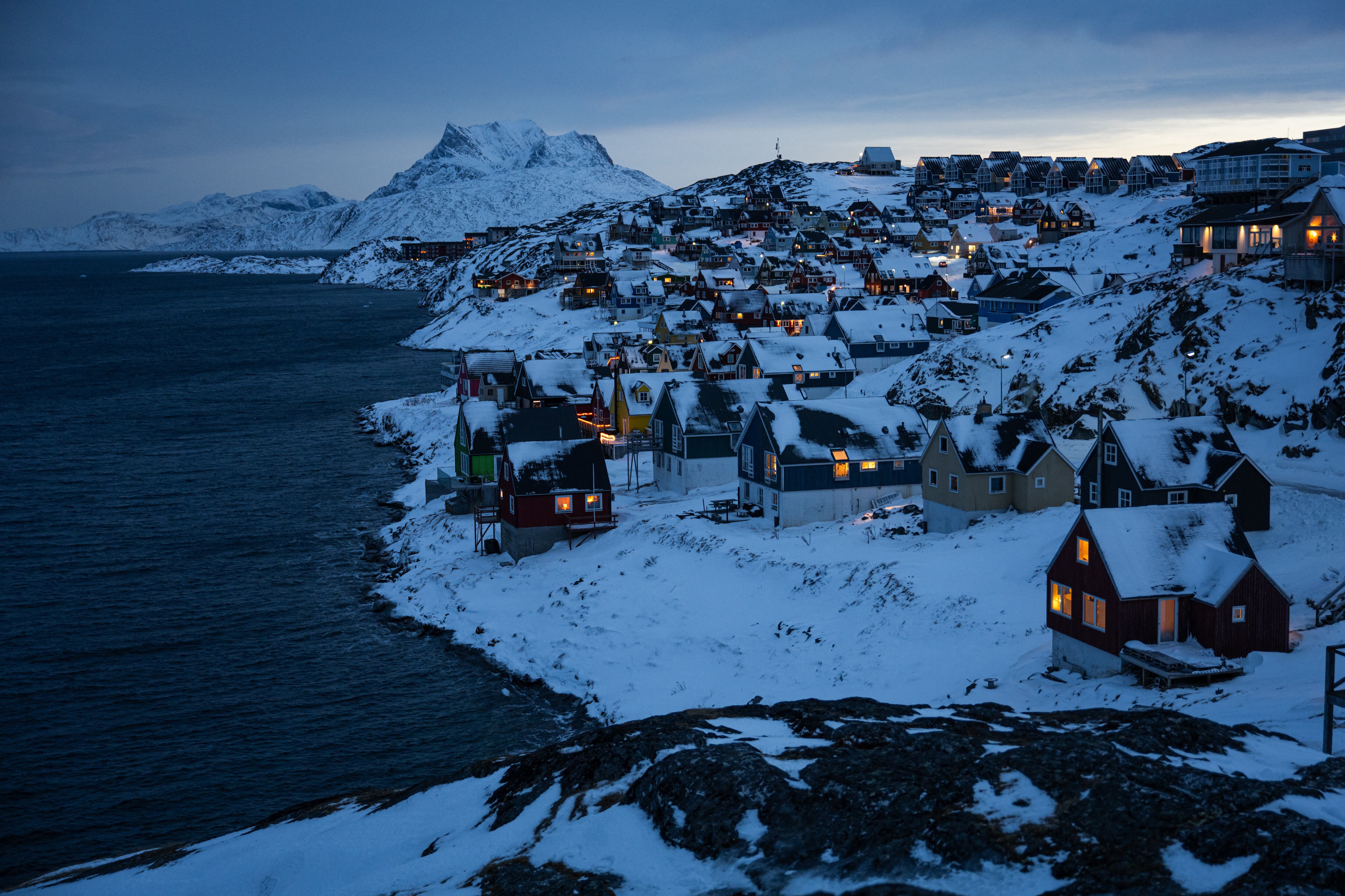 Las casas a lo largo de la costa durante la luz del amanecer entre las colinas nevadas en Nuuk, Groenlandia, este 22 de enero. Fotografía: