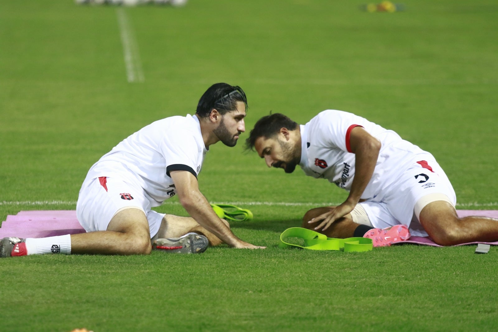 Aarón Salazar y Celso Borges estiran antes de la práctica en el Estadio Francisco Morazán, en San Pedro Sula, donde Alajuelense jugará este jueves.