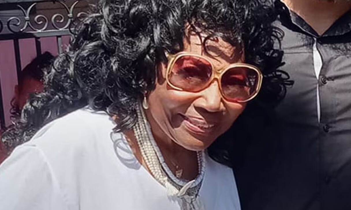 Imagen en primer plano de la actriz Dalyce Curry usando una blusa blanca y lentes para sol.