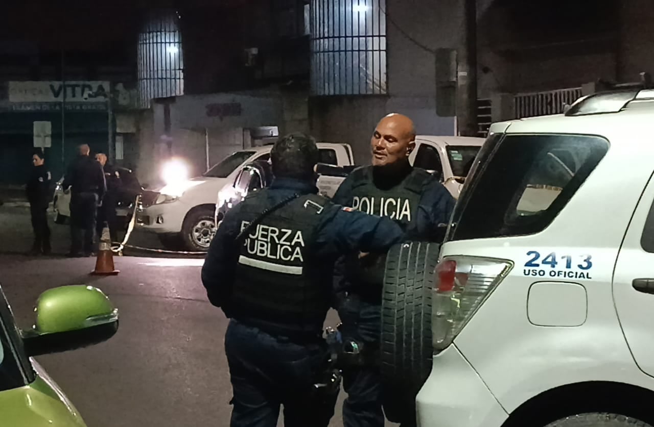 Oficiales de Fuerza Pública custodiaron el hallazgo de un hombre baleado dentro de un vehículo frente a Emergencias del hospital Max Peralta, en Cartago, la noche de este domingo. Fotografía: