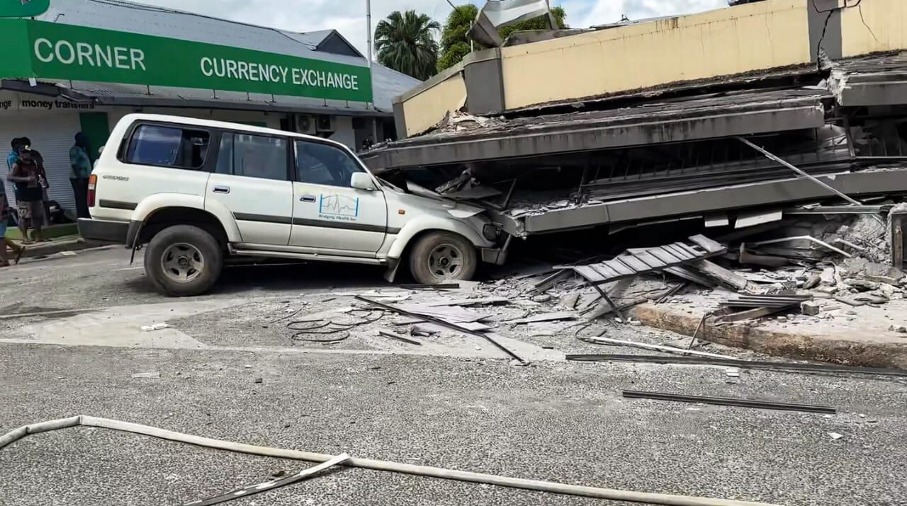 Auto dañado atrapado bajo un edificio colapsado en Port Vila, Vanuatu, tras un terremoto de magnitud 7.3 que sacudió la isla principal.