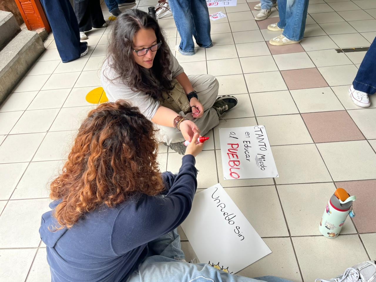 Estudiantes preparan carteles como parte de la movilización vinculada con la campaña “Seguimos aquí”.