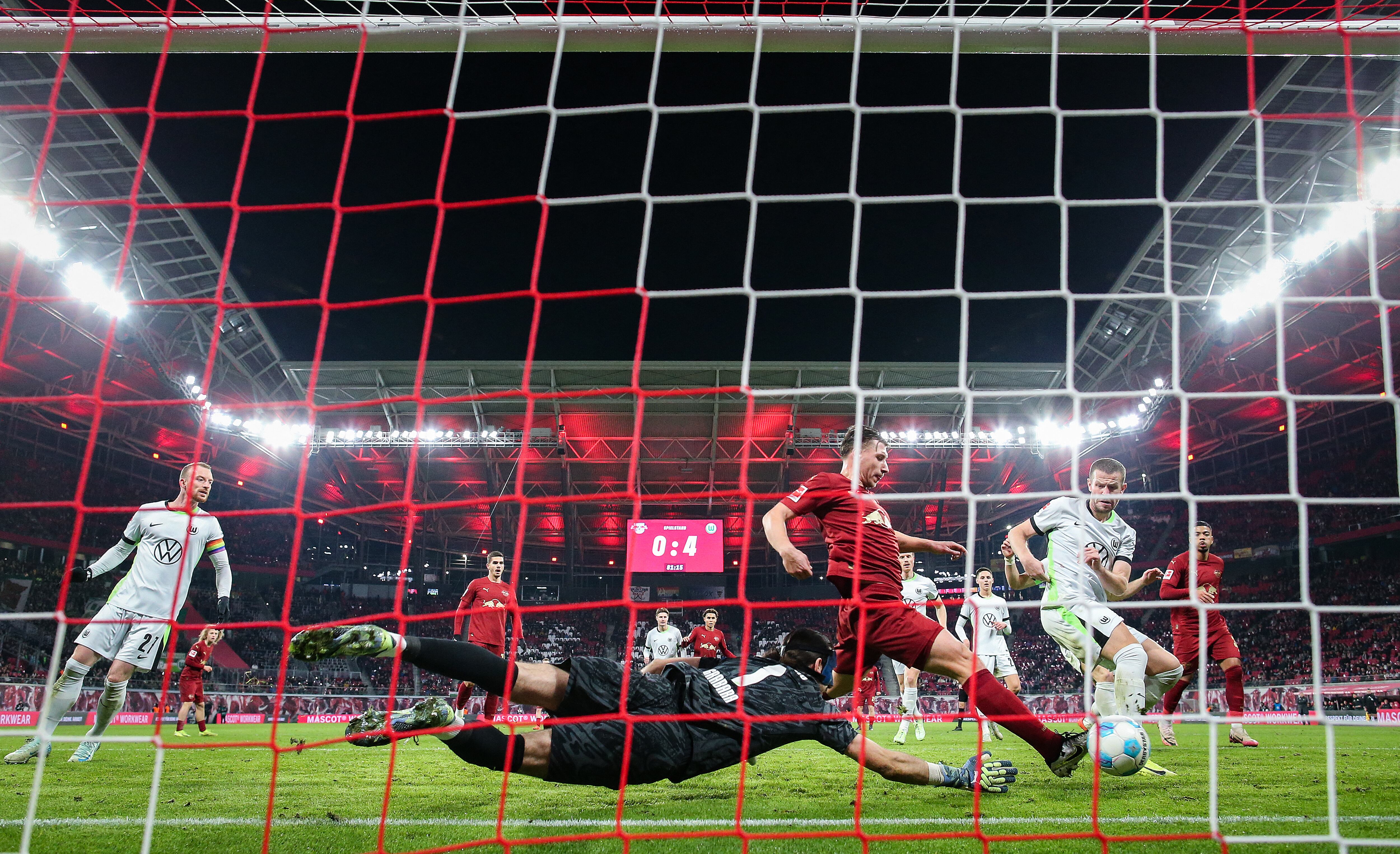 Leipzig's Hungarian defender #04 Willi Orban scores the 1-4 against Wolfsburg's Polish goalkeeper #01 Kamil Grabara during the German first division Bundesliga football match RB Leipzig v VfL Wolfsburg in Leipzig, eastern Germany on November 30, 2024. (Photo by RONNY HARTMANN / AFP) / DFL REGULATIONS PROHIBIT ANY USE OF PHOTOGRAPHS AS IMAGE SEQUENCES AND/OR QUASI-VIDEO