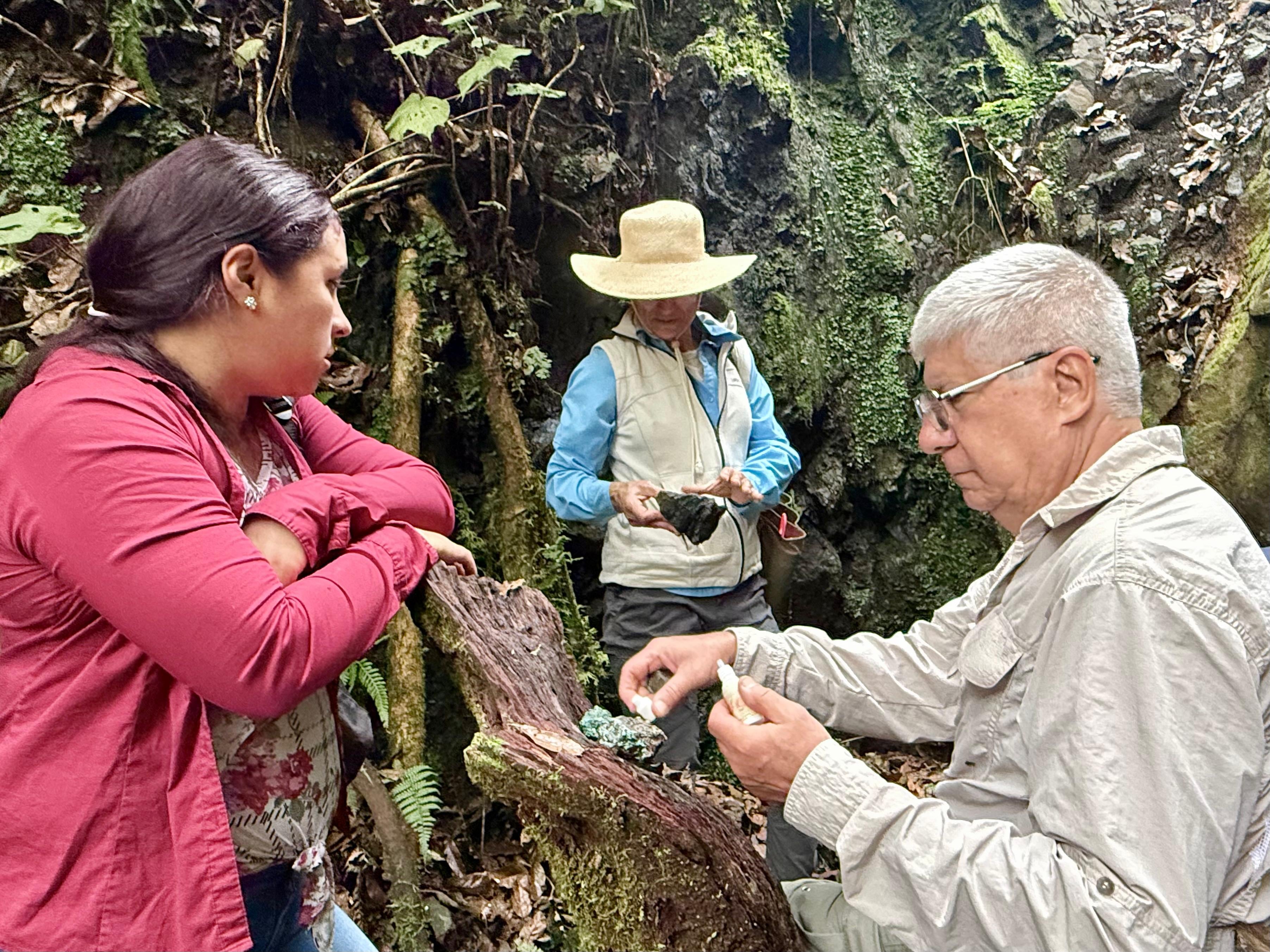 Magaly, Emma Tristán y el geólogo Guillermo Alvarado observan los fragmentos de roca en la boca de la “mina”.