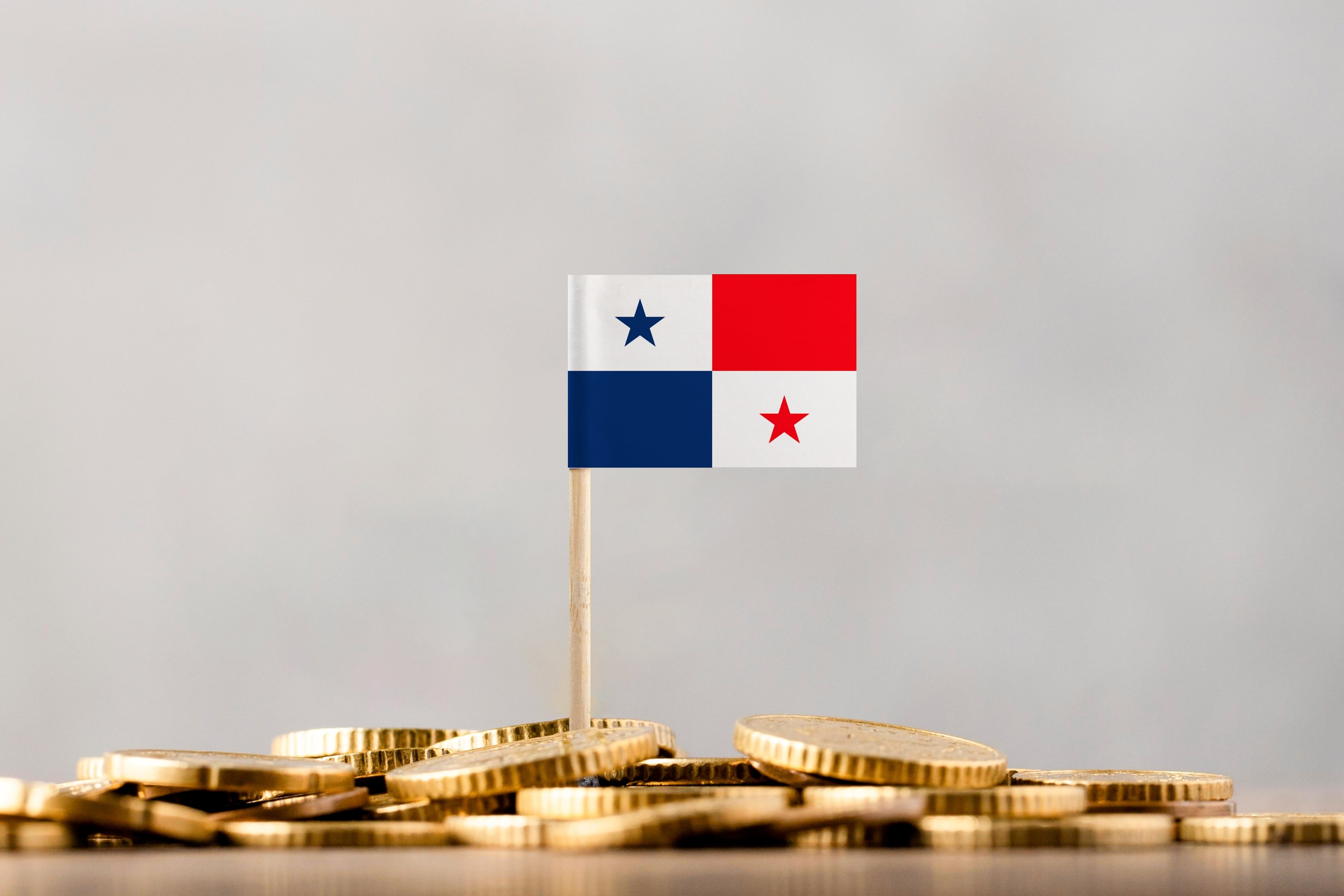 Bandera de Panamá sobre monedas apiladas