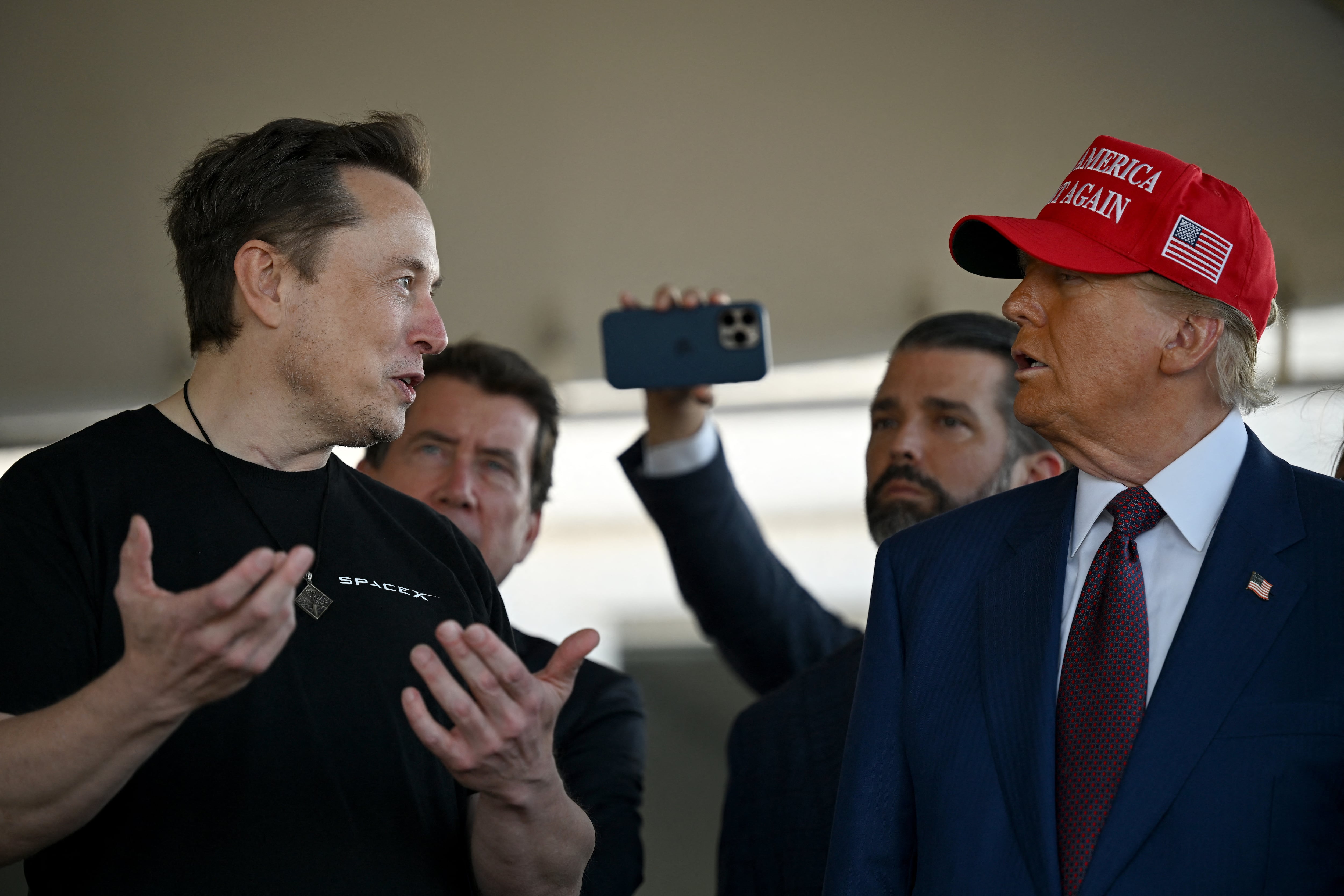 Elon Musk, empresario y dueño de SpaceX, dialoga con Donald Trump, presidente electo de Estados Unidos, reflejando la relación entre líderes tecnológicos y el gobierno republicano.