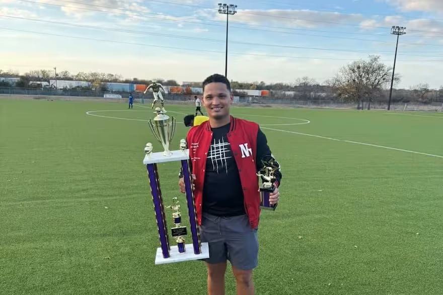 Mervin Yamarte, joven venezolano, sonríe mientras sostiene un trofeo de fútbol en Dallas, Texas, antes de su arresto y deportación a El Salvador.