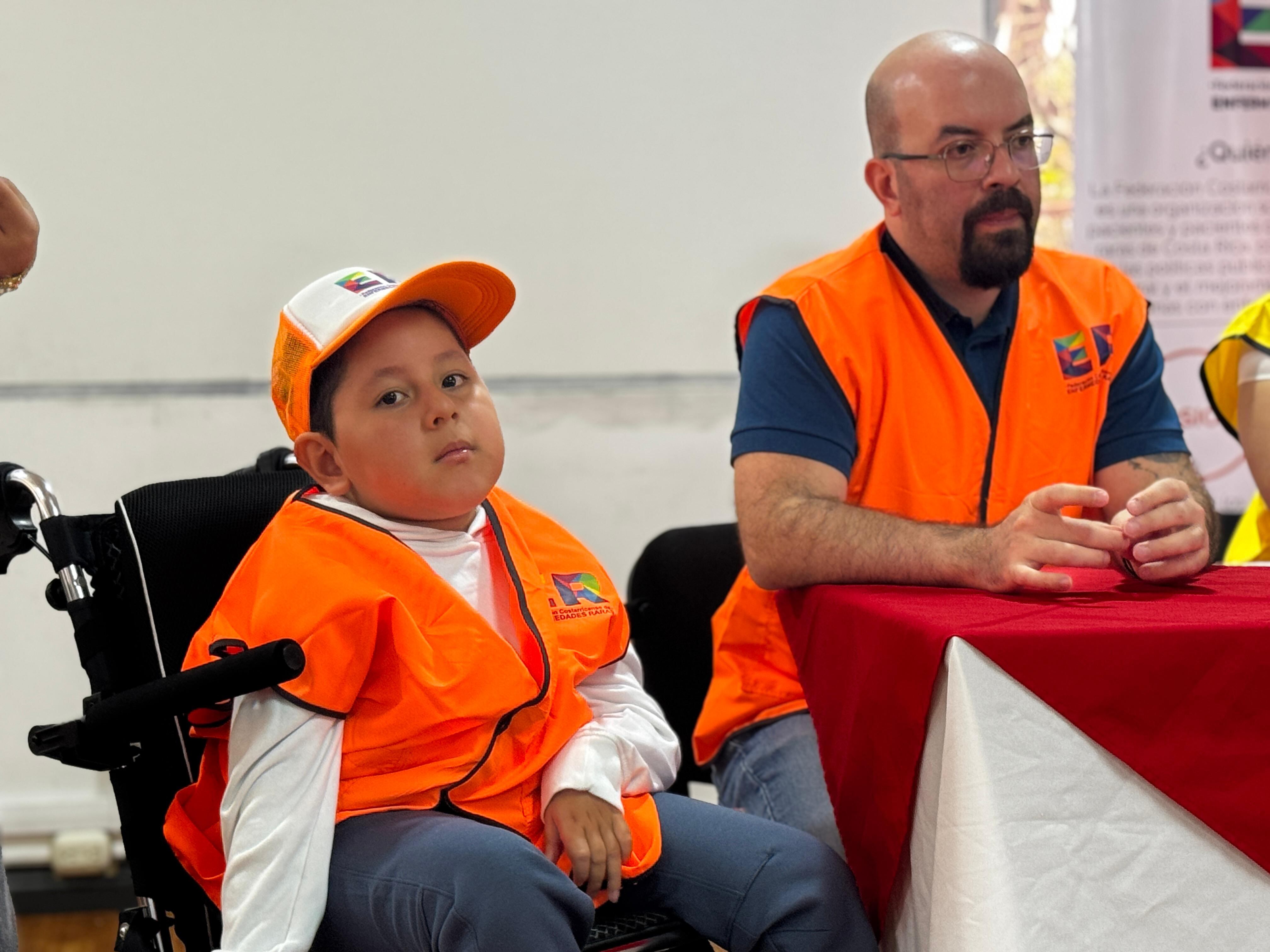 Un niño en silla de ruedas, al fondo,, un médico hablando.