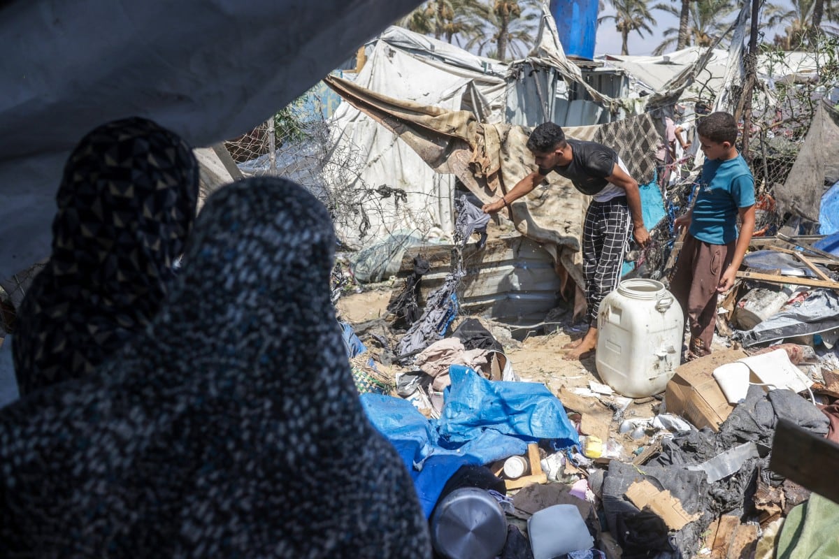 Palestinos desplazados inspeccionan los daños en el lugar de un supuesto ataque israelí contra una tienda de campaña en Jan Yunis, en el sur de la Franja de Gaza, el 16 de agosto de 2026.