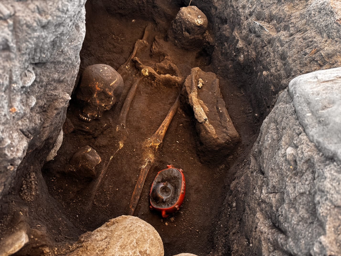 Una tumba con un esqueleto y las ofrendas con las que fue enterrado.