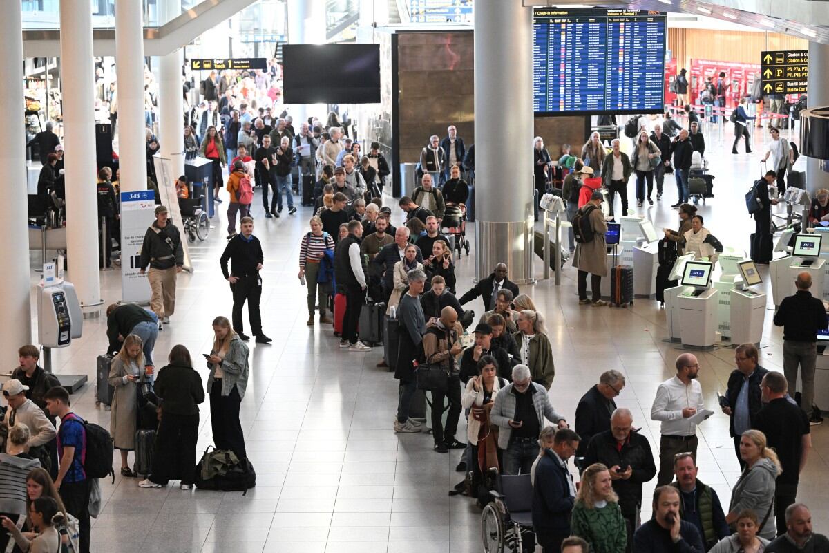 Passengers stand in a queue to get new tickets at the service point of the Copenhagen Airport in Copenhagen, Denmark, on September 23, 2025. Danish police said that whoever was responsible for flying large drones over Copenhagen airport appeared to have been knowledgeable, as flights resumed in Denmark and Norway capitals following a night of travel chaos. Airports in Copenhagen and Oslo reopened on Tuesday, September 23, hours after unidentified drones in their airspace caused dozens of flights to be diverted or cancelled, disrupting thousands of passengers. (Photo by Sergei GAPON / AFP)