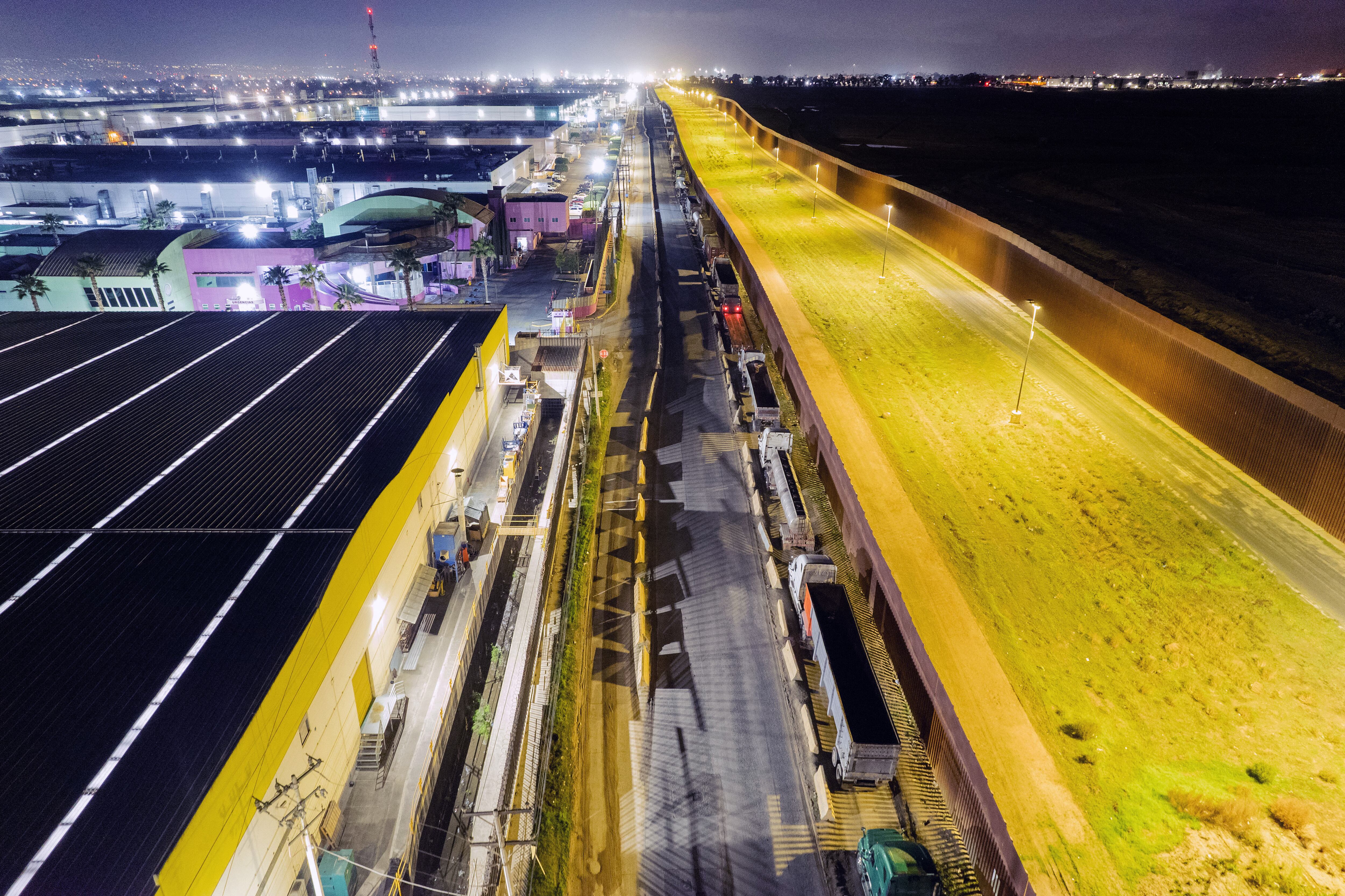 (FILES) Aerial view showing trucks queuing near the Mexico-US border while waiting for the port to open in Otay Commercial crossing in Tijuana, Baja California state, Mexico, on March 4, 2025. The US trade deficit surged to a new record