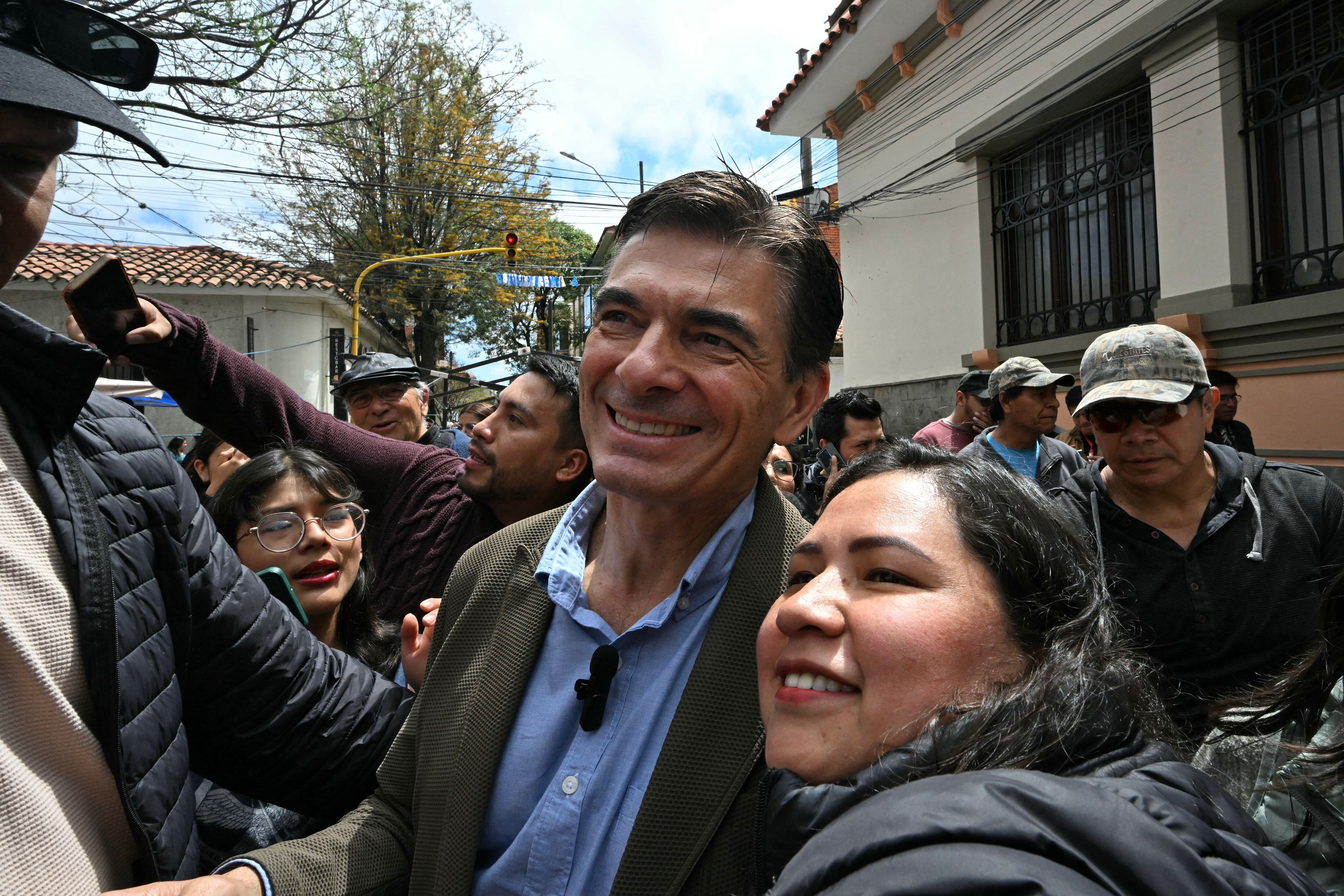 El candidato presidencial de Bolivia por el Partido Demócrata Cristiano (PDC), Rodrigo Paz (C), posa para una selfie con un partidario después de votar durante la segunda vuelta de las elecciones presidenciales en Tarija, Bolivia, el 19 de octubre de 2025.