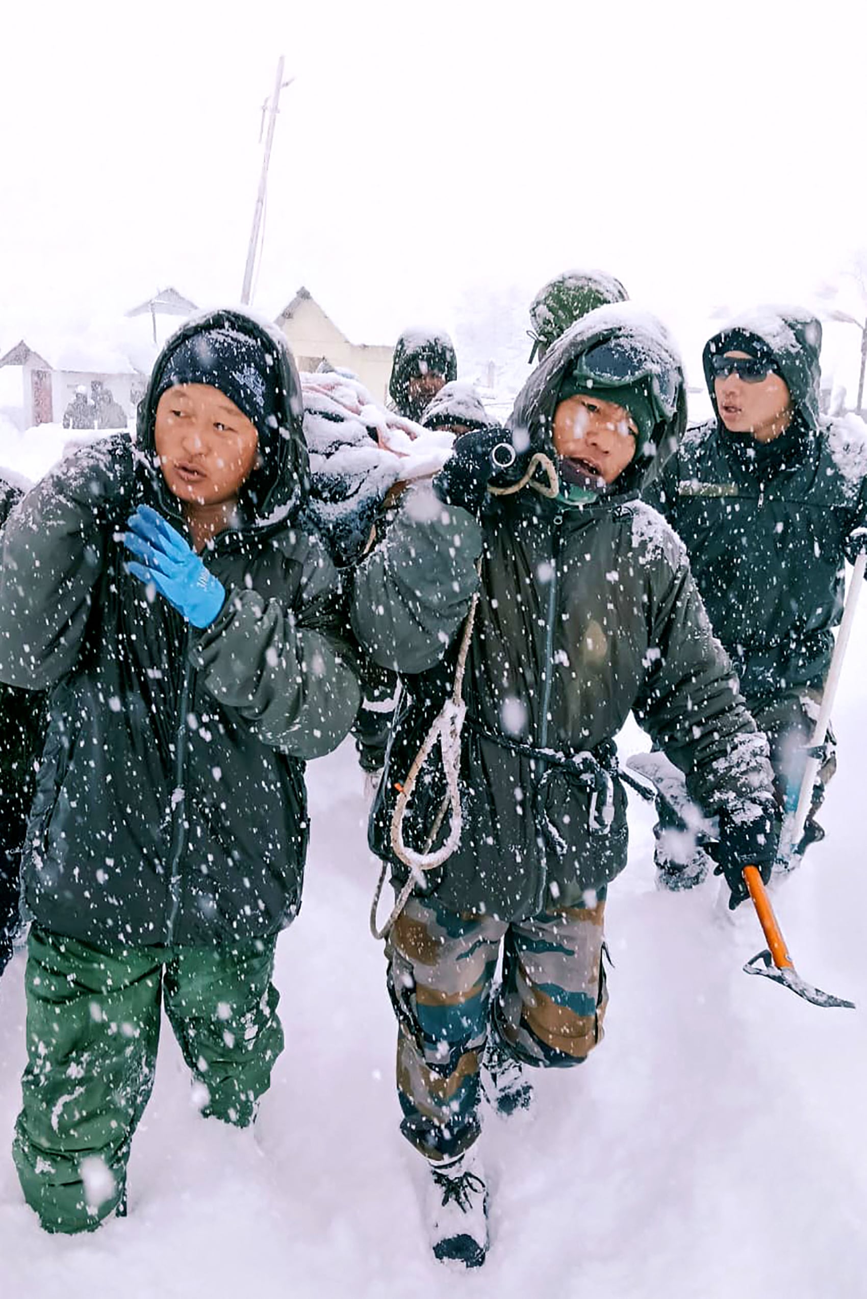 In this handout photo taken and released by the State Disaster Response Force (SDRF) on February 28, 2025, rescuers carry Border Roads Organisation (BRO) workers after an avalanche near Mana village in Chamoli district. Over 40 const