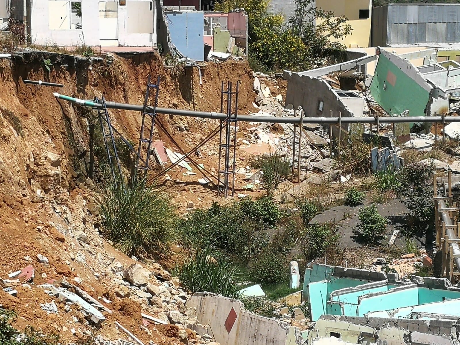 La municipalidad colocó un tubo para evitar que el agua de lluvia se empoce, sin embargo el retraso en la adjudicación de obras estabilizadoras preocupa a vecinos de Valladolid. Foto: Marisol Salguero.