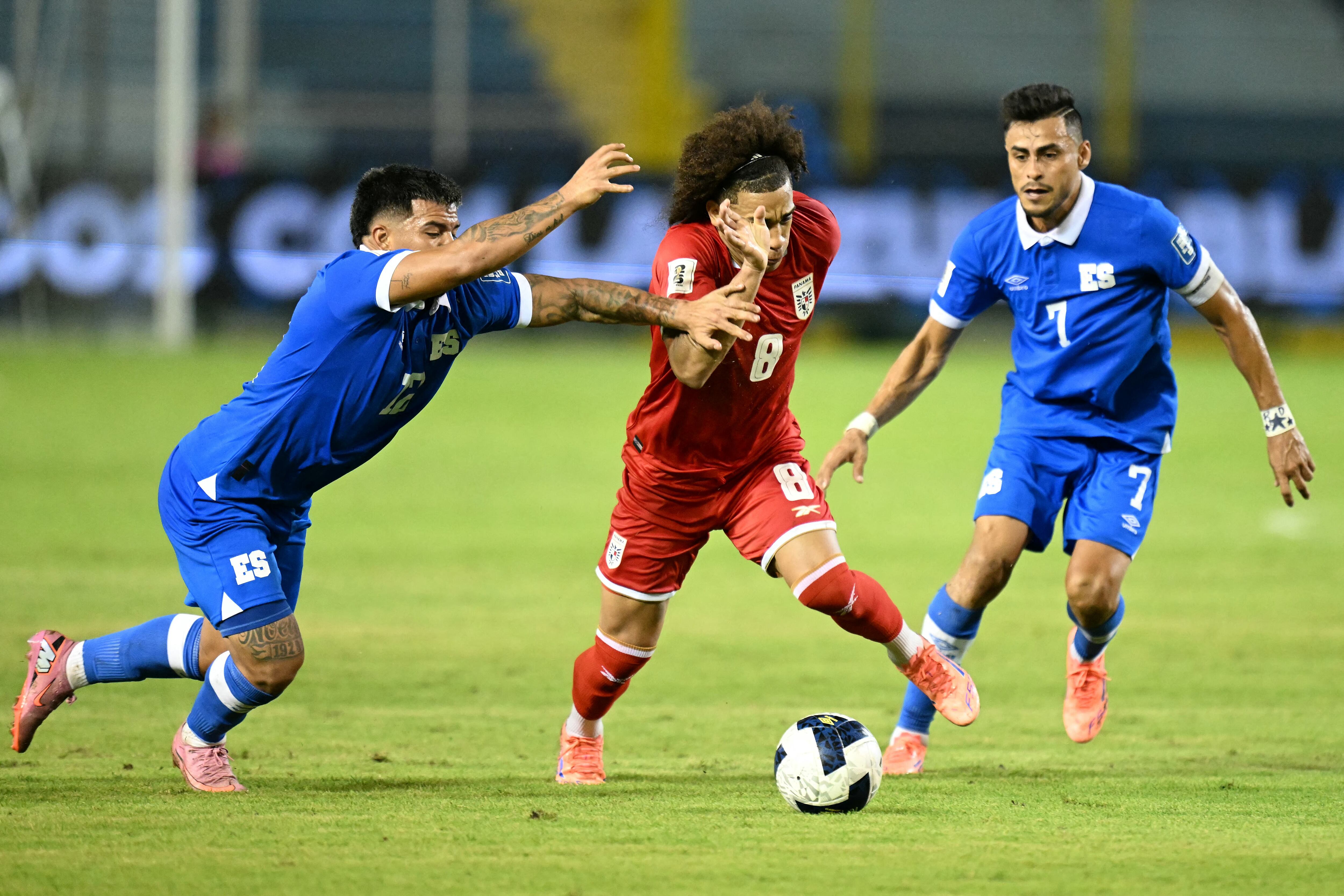 El panameño Adalberto Carrasquilla trata de eludir la marca de los salvadoreños Marcelo Díaz y Darwin Cerén, por la eliminatoria de Concacaf rumbo al Mundial 2026.