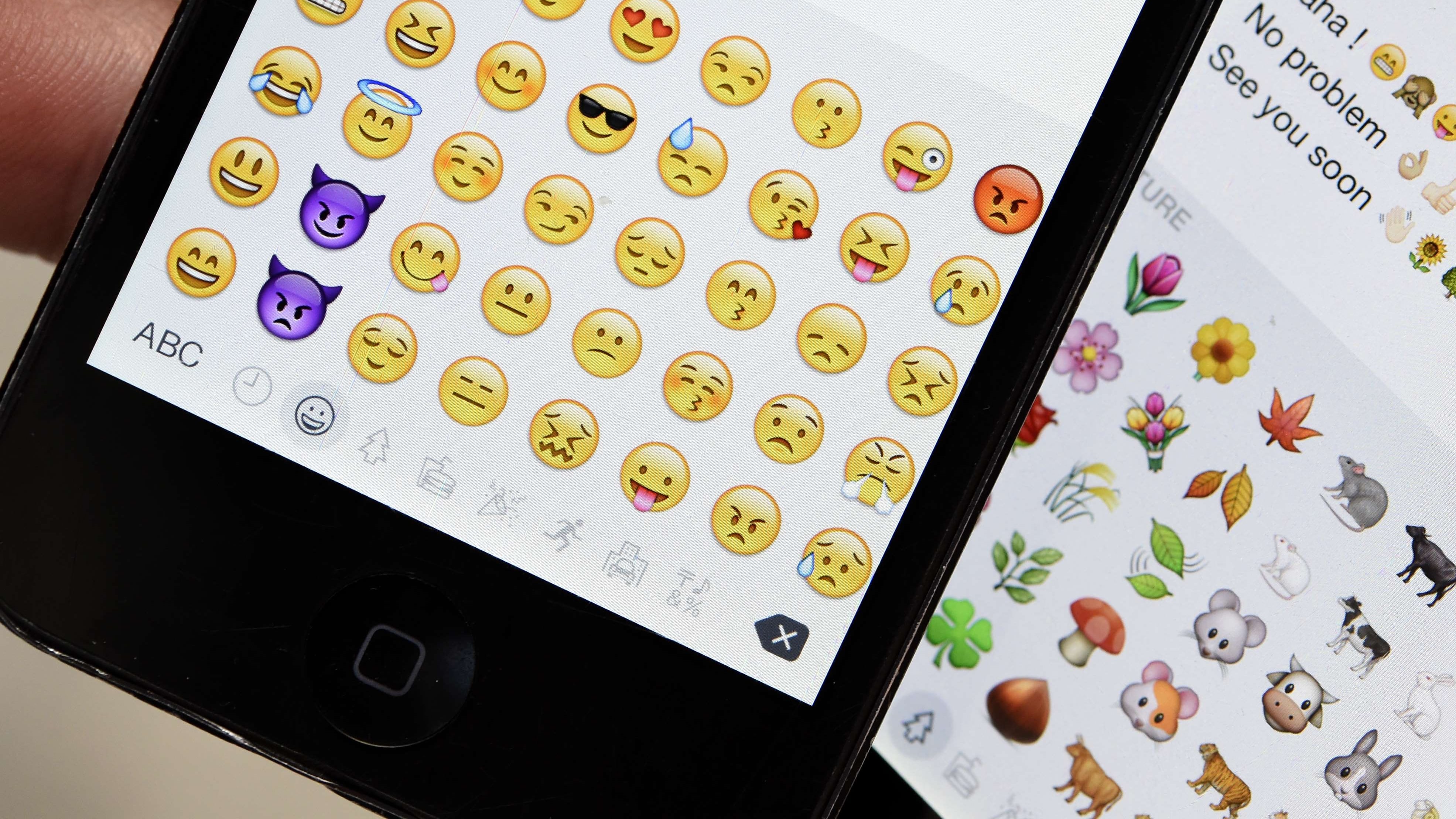 A picture shows emoji characters also known as emoticons on the screens of two mobile phones in Paris on August 6, 2015. Forget traditional banners and promotional videos, brands are turning to emojis to communicate with their Generation Z target audience. AFP PHOTO / MIGUEL MEDINA