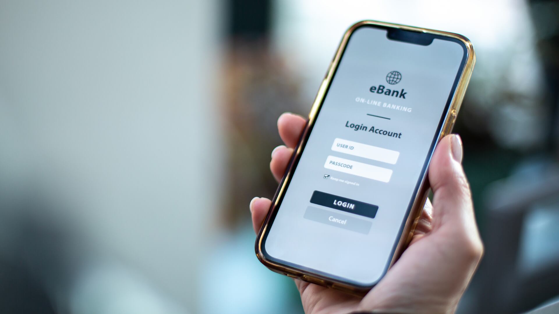 Primer plano de un teléfono móvil mostrando la pantalla de inicio de sesión de una aplicación bancaria llamada eBank, con campos para usuario y contraseña.