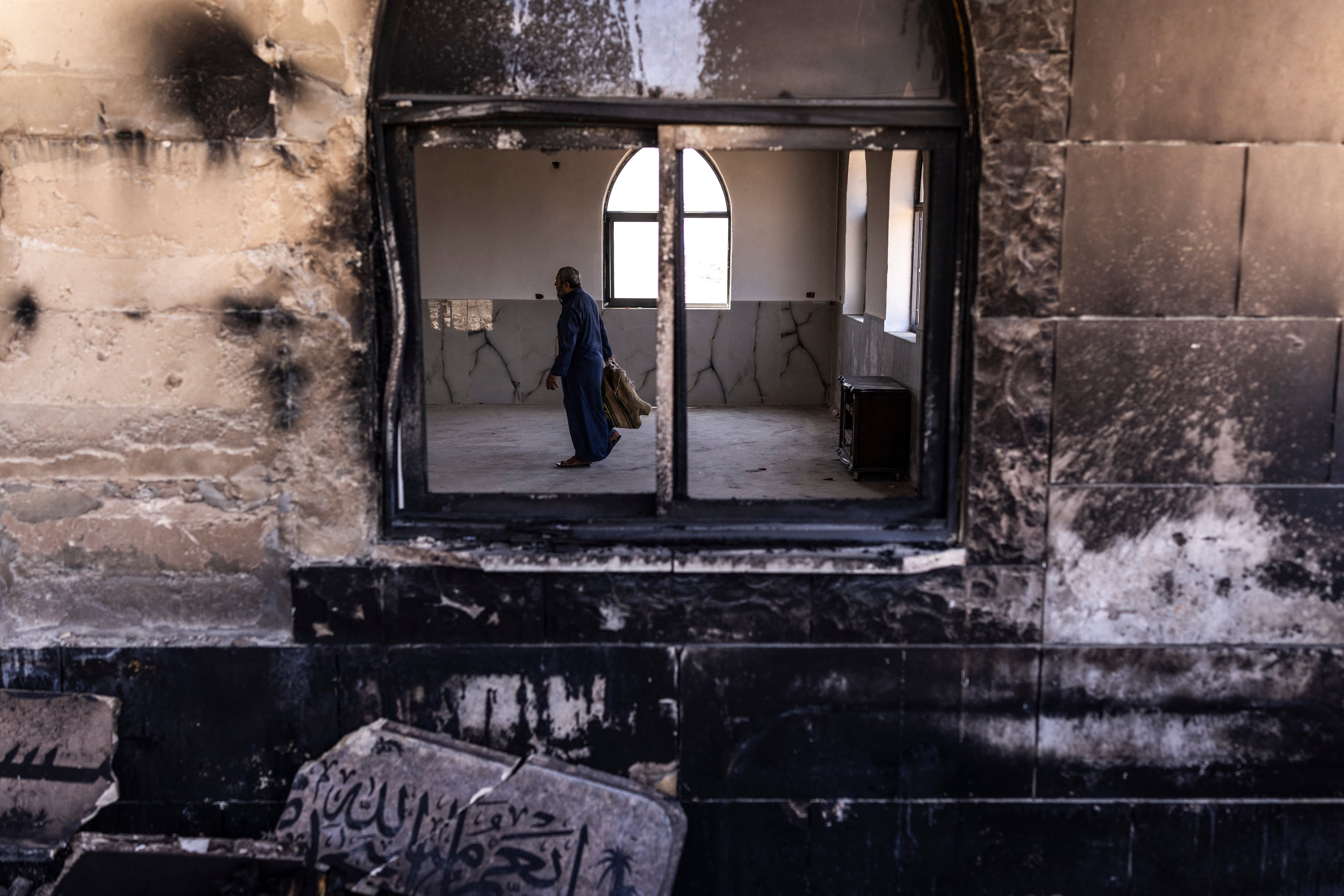 A Palestinian man prepares to pray at a mosque allegedly burned by Israeli settlers in the village of Qusra