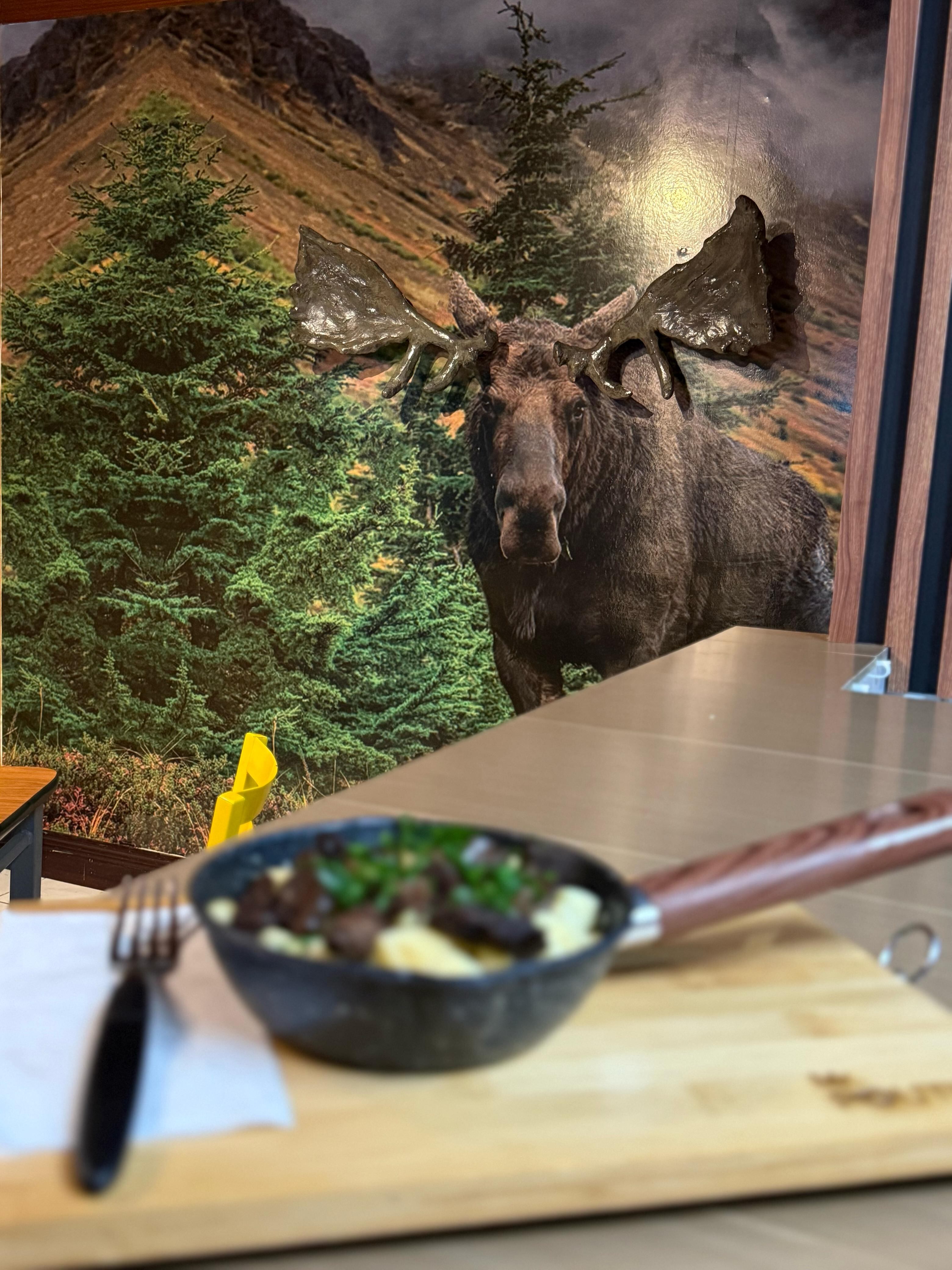 El local de Mr. Poutine cuenta con decoración inspirada en Canadá, incluyendo un alce en 3D y un menú con nombres de provincias canadienses.