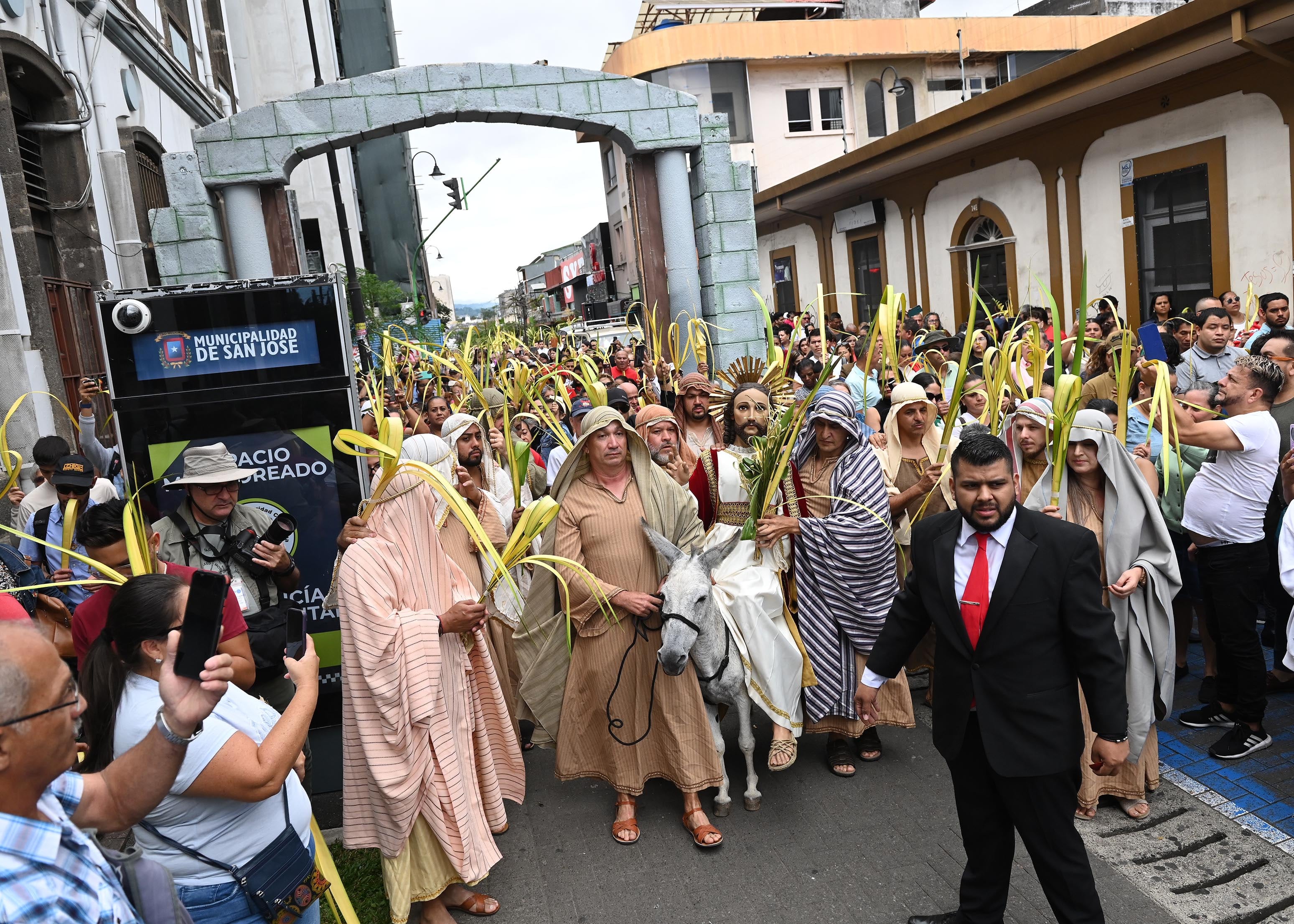 13 de abril del 2025. San José. 09:30 hrs. Tradicional proseción de Domingo de Ramos que marca el inicio de la Semana Mayor en el país. Cientos de personas iniciaron el recorrido de la imagen de Jesús sobre los lomos de la mula chepita mientras sostenían las tradicionales palmas y cantaban. canciones alusivas. El recorrido inició en la parroquia de La Soledad y finalizó en la Catedral Metropolitana que lucía y lleno total. En la foto: Recorrido de la imagen de Cristo sobre los lomos de chepita a lo largo de la avenida 4 hasta llegar e ingreasar a la Catedral. Eypriel Bermúdez Cabezas (4) vecina de Desamparados. Foto: Albert Marín para la Teja.