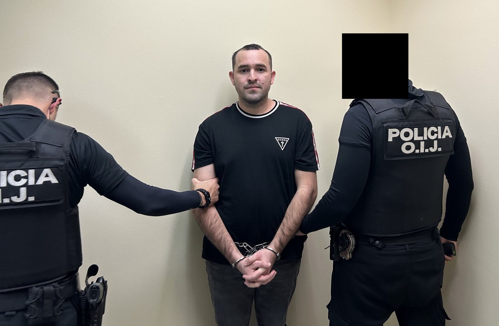 Josseth Santos-Fonseca, esposado y flanqueado por dos oficiales del OIJ, tras su deportación a Costa Rica por delitos de narcotráfico.