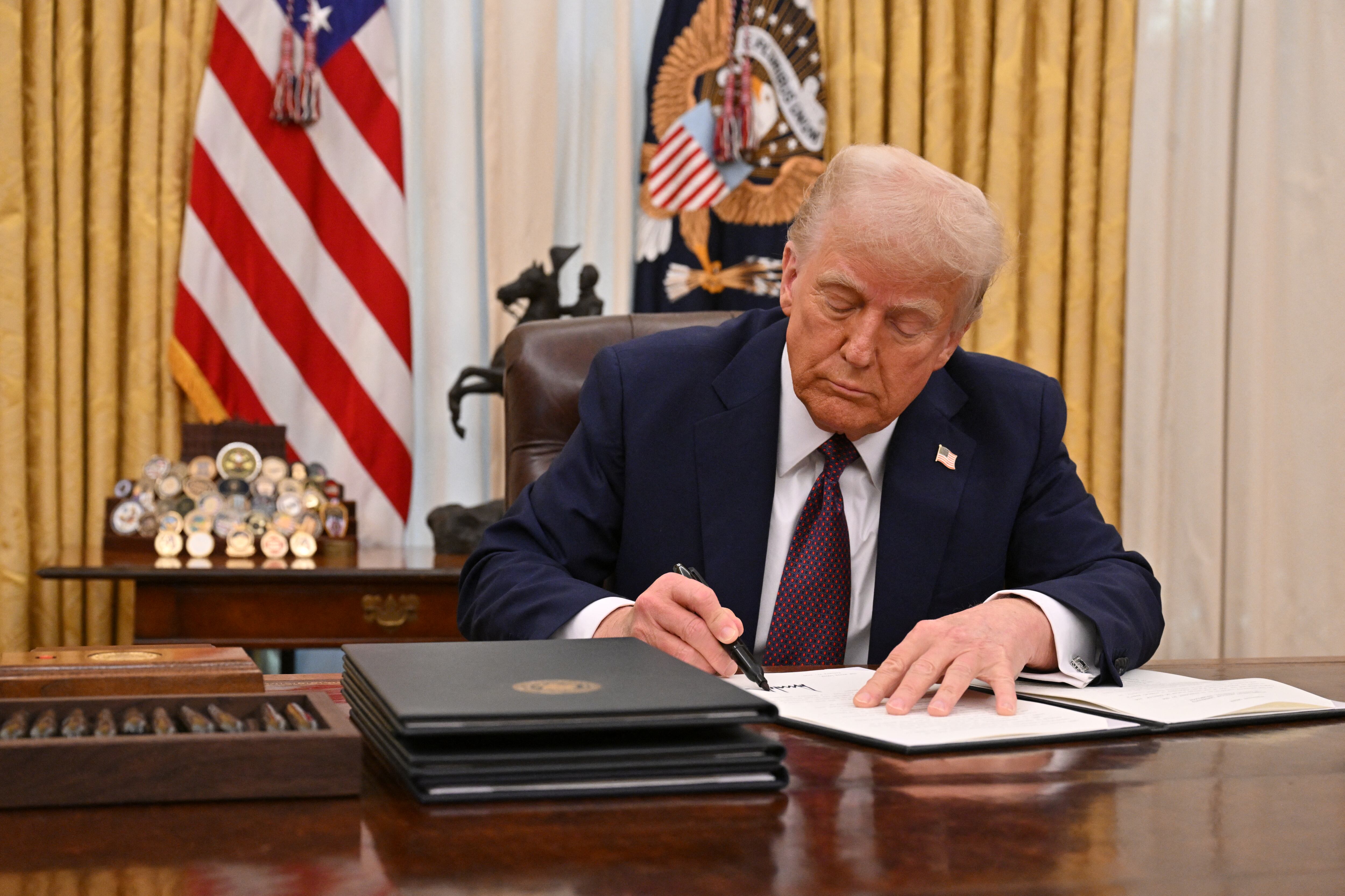 Donald Trump, presidente de Estados Unidos, hablando en el Capitolio frente a una bandera estadounidense, durante su discurso inaugural en 2025.