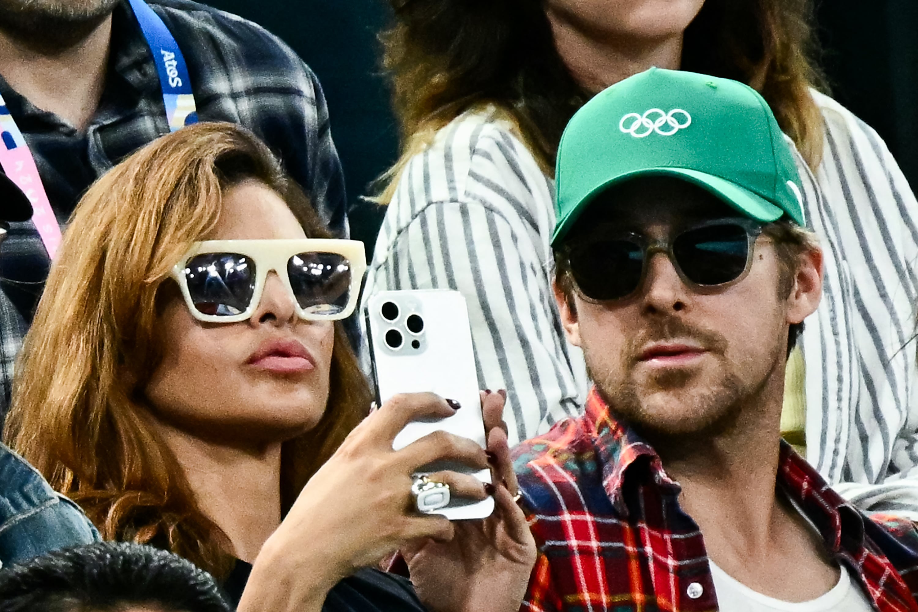 La actriz estadounidense Eva Mendes (izq.) y su pareja, el actor canadiense Ryan Gosling (der.), asisten a la final femenina de barras asimétricas de gimnasia artística durante los Juegos Olímpicos de París 2024, en el Bercy Arena de París, el 4 de agosto de 2024. (Foto: Loic Venance / AFP)