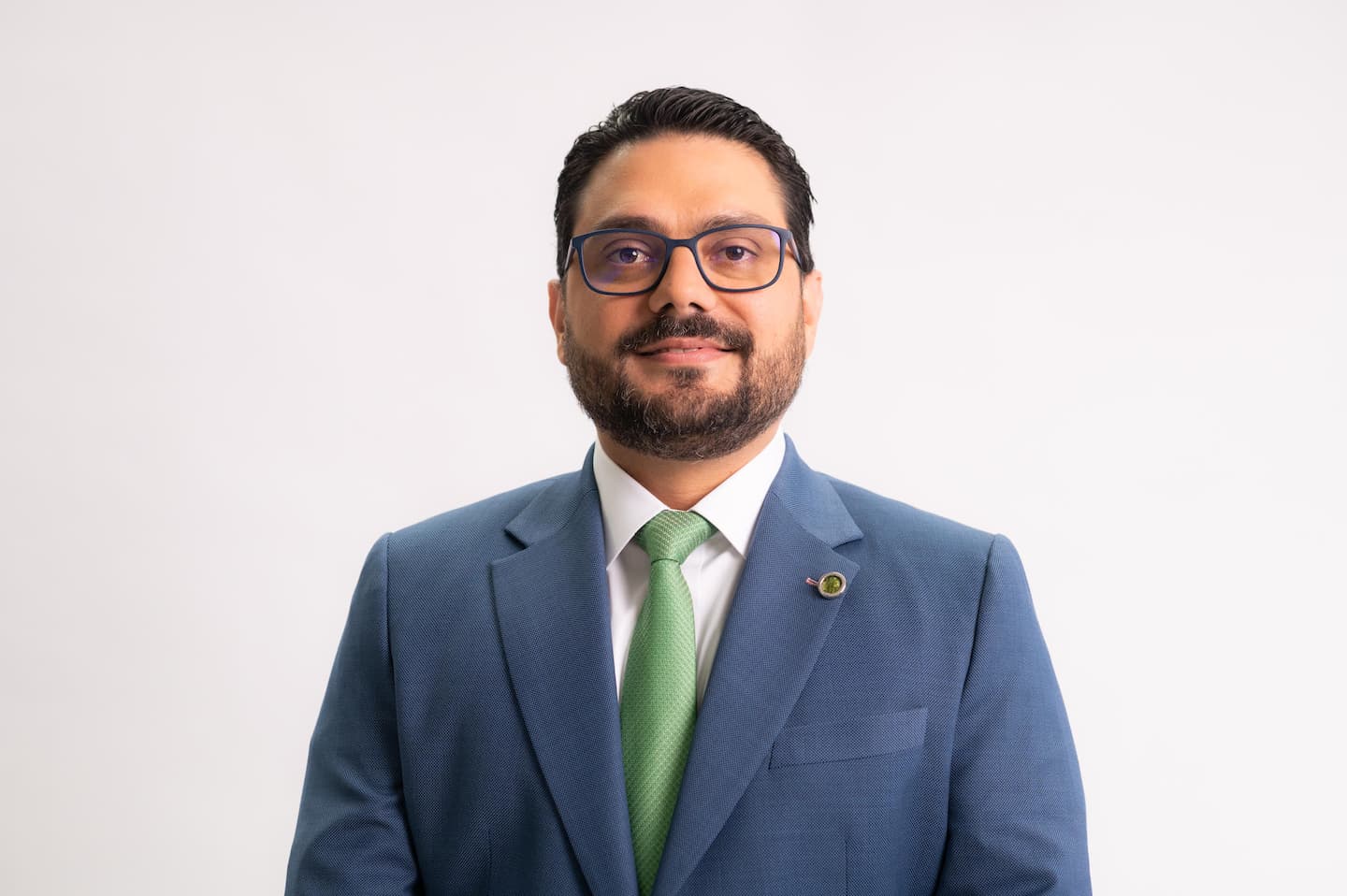 Fabio Salas, socio de Impuestos y Servicios Legales en Deloitte Costa Rica, con traje azul y corbata verde, en un retrato corporativo.