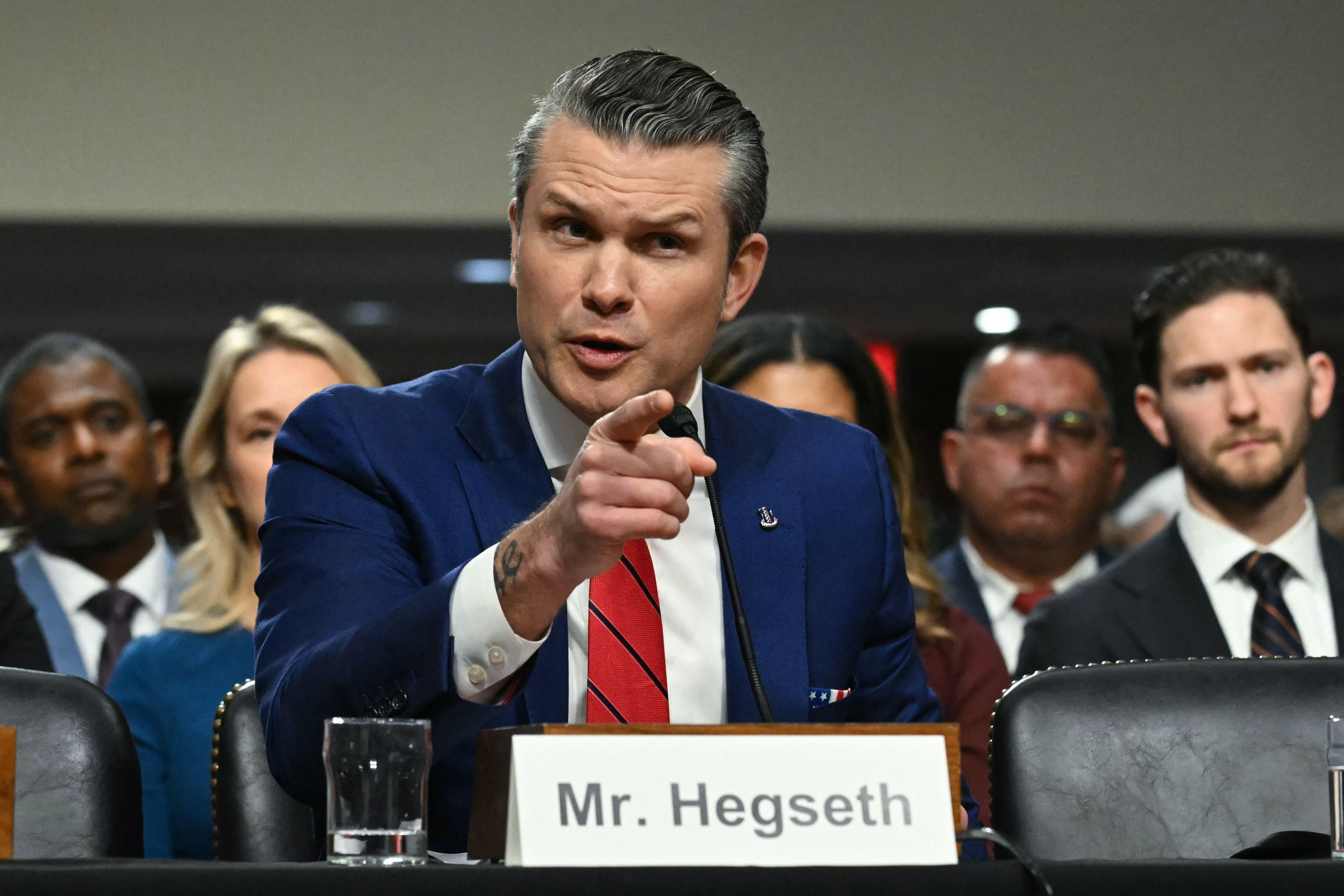 Pete Hegseth, vestido de traje azul, gesticulando en una audiencia del Senado, donde fue ratificado como secretario de Defensa de Estados Unidos.