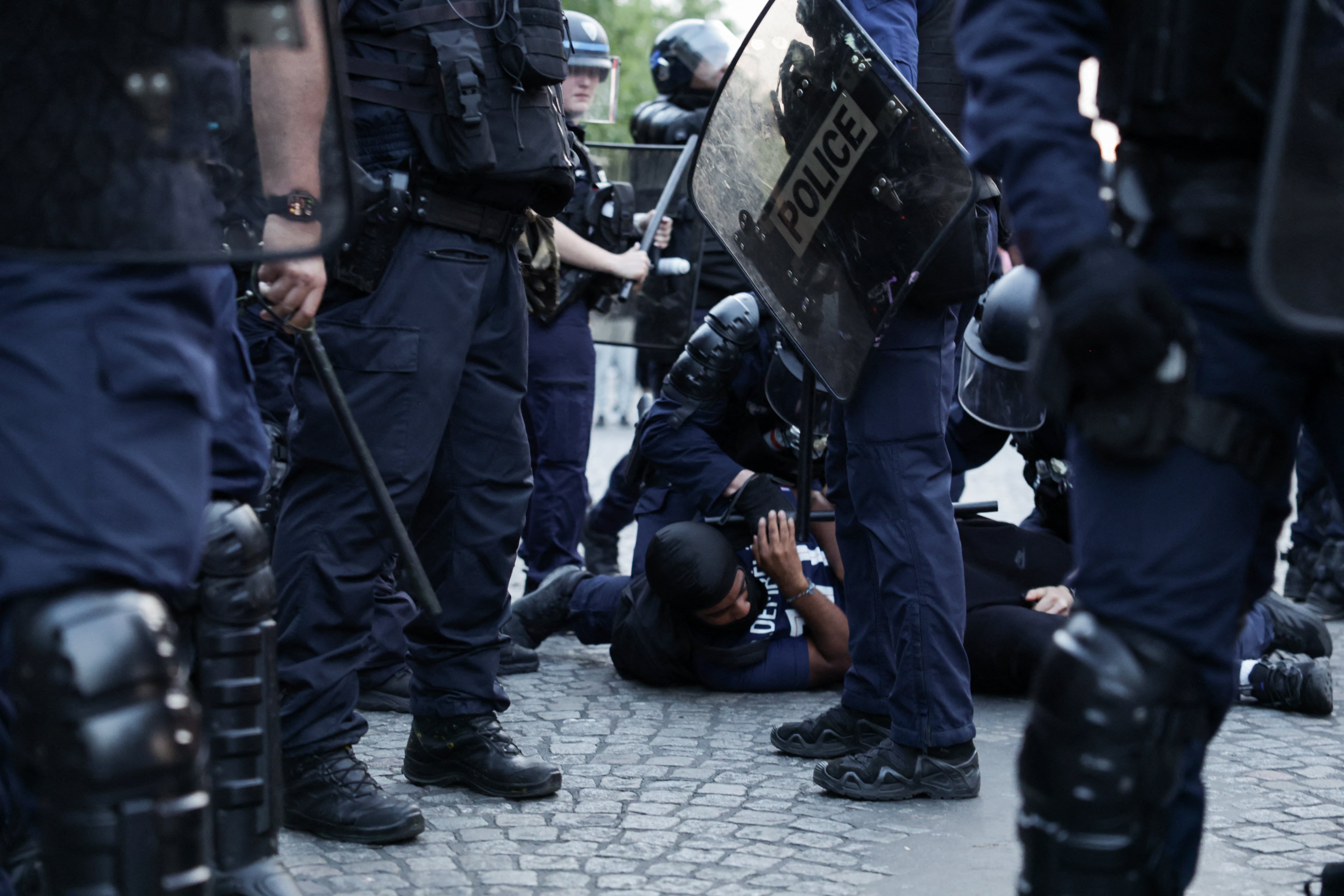 Agentes de la Policía Republicana de Seguridad (CRS) detienen a un aficionado del Paris Saint-Germain durante las celebraciones por la victoria del club en la final de la Liga de Campeones de la UEFA ante Arsenal, en los Campos Elíseos de París, Francia, este 30 de mayo de 2026. Foto: AFP / Romeo Boetzle.