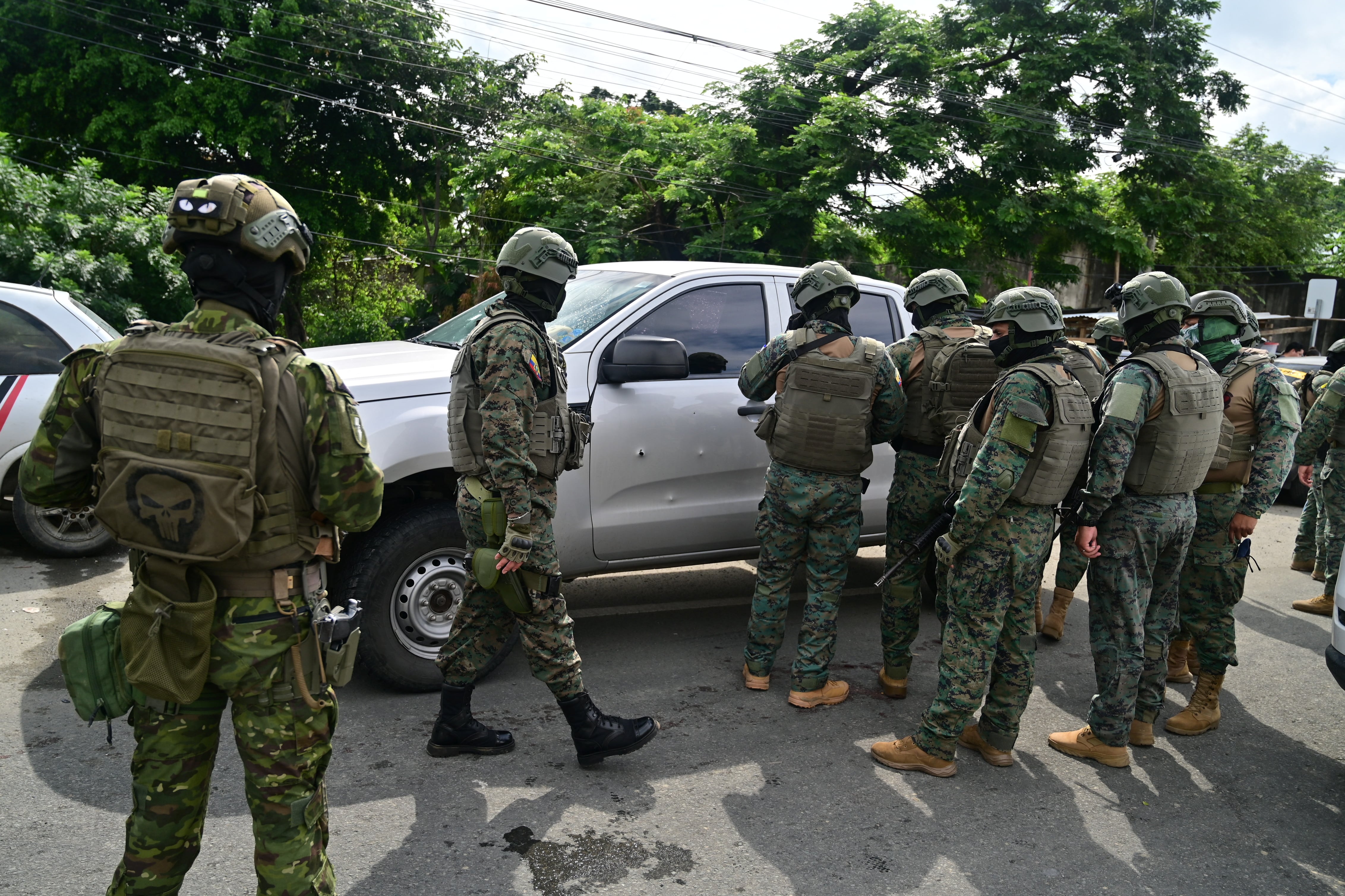 Military officers inspect the pickup truck in which a colonel of the Ecuadorian Armed Forces was murdered in Guayaquil, Ecuador, on February 14, 2025. A colonel of Ecuador's Armed Forces was shot dead on Friday nea