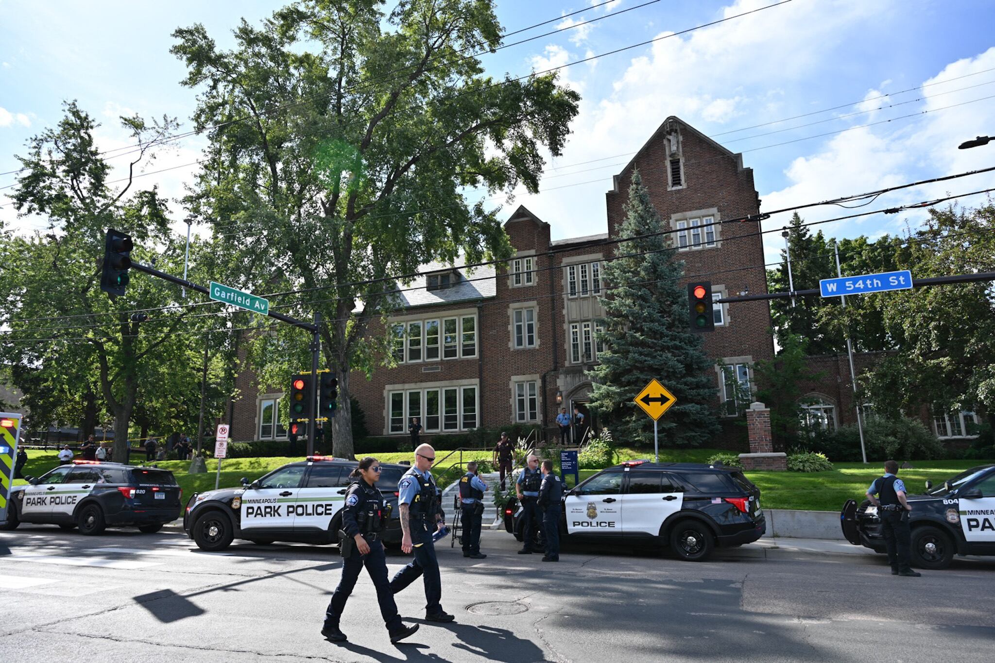 Police and first responders work at the scene of a shooting near Annunciation Church and Catholic School in Minneapolis, Minneosta, on August 27, 2025. Two children were shot dead when a gunman attacked a Minneapolis church on Wednesday, with 17 people injured, 14 of them children, police said. The gunman "began firing a rifle through the church windows towards the children sitting in the pews at the mass," Minneapolis police chief Brian O'Hara told reporters. The pupils were marking the first week of the school year when the attack occurred. (Photo by TOM BAKER / AFP)