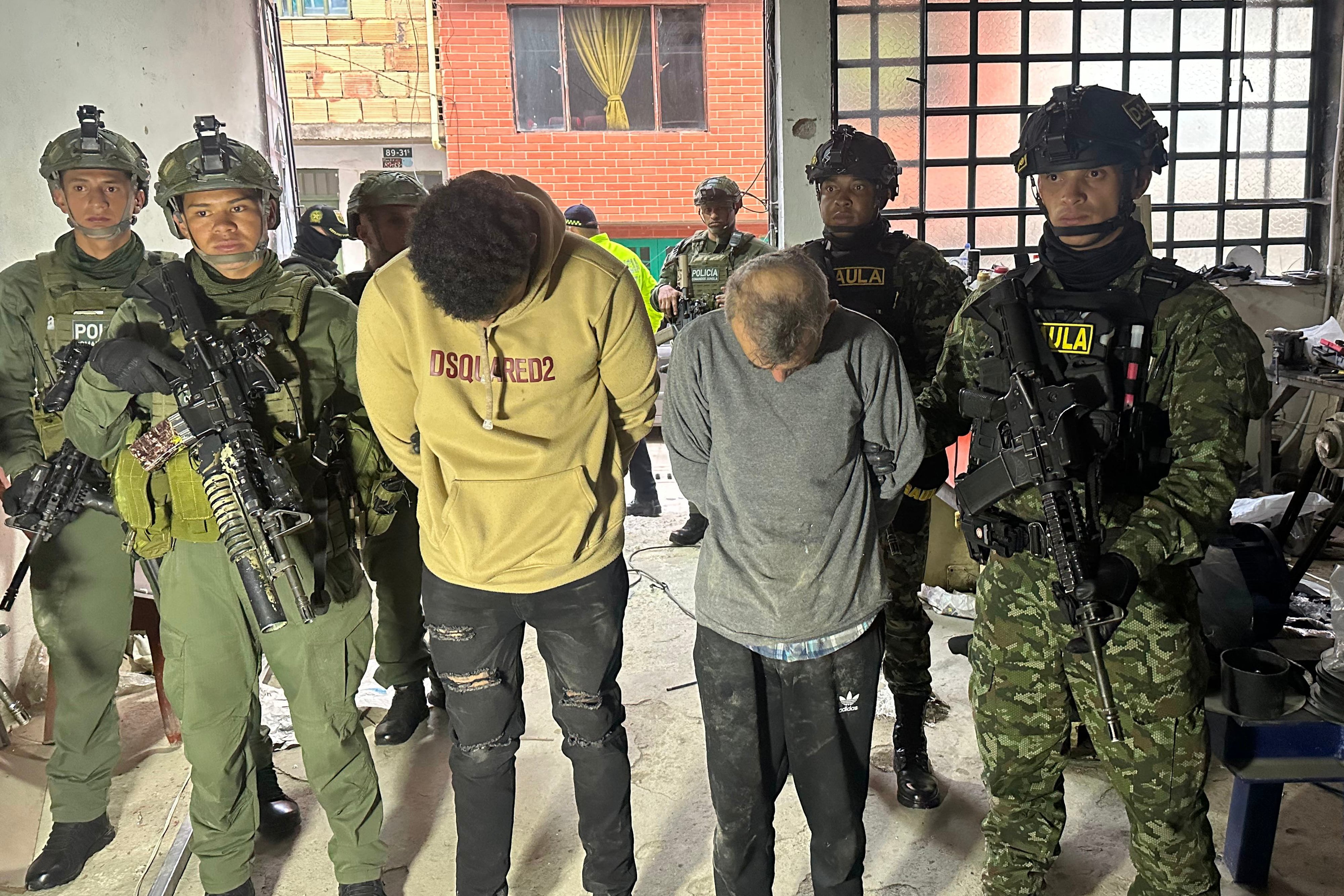 Imagen difundida por la Oficina de Prensa del Ejército de Colombia que muestra a miembros de los Grupos de Acción Unificada por la Libertad Personal (GAULA) escoltando a presuntos miembros de la guerrilla del ELN después de allanar un depósito en Bogotá.