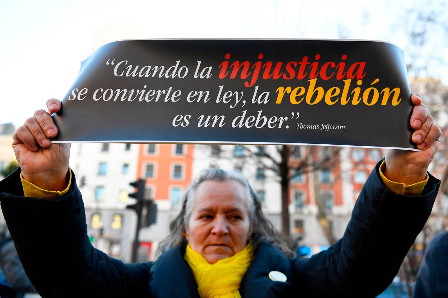 A woman holds a sign reading "When injustice becomes law, rebellion is a must" during a protest against the trial of jailed Catalan separatists at the Supreme Court in Madrid on February 12, 2019. - Twelve former Catalan leaders go on trial at Spain's Supreme Court for their role in a failed 2017 bid to break away from Spain. (Photo by GABRIEL BOUYS / AFP)