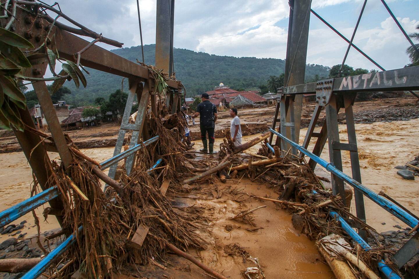 Villagers check the condition of a bridge destroyed by a flood at the Banjar Irigasi village in Lebak, Banten province on January 2, 2020, after flooding triggered by heavy rain hit the area. - Indonesia's disaster agency warned on January 2 of more deaths after torrential rains pounded the Jakarta region, triggering floods and landslides that killed at least 23 and left vast swaths of the megalopolis underwater. (Photo by SAMMY / AFP)