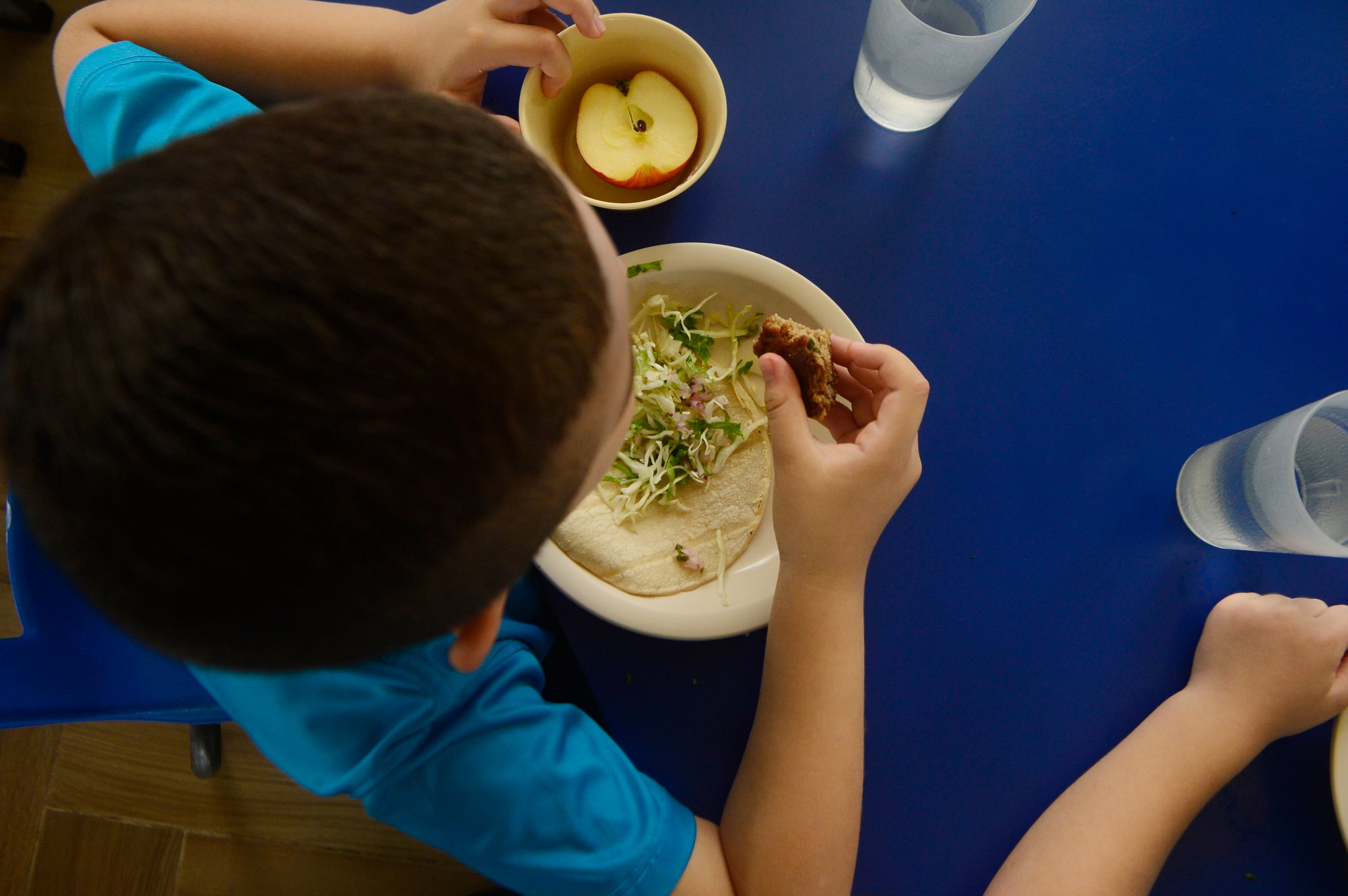 Niño almuerza en comedor escolar