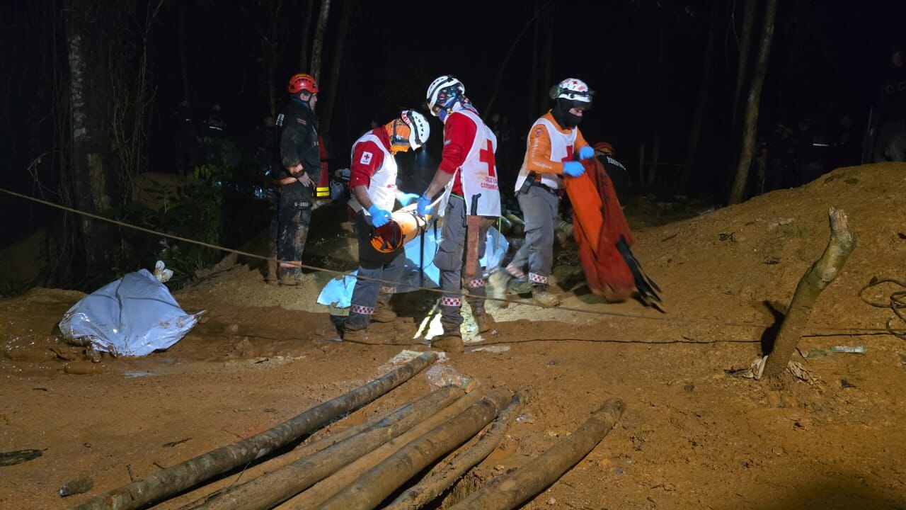 Cruzrojistas en Crucitas la madrugada de este miércoles junto a uno de los cuerpos extraídos de la mina que colapsó y cobro la vida de dos mineros. Fotografía: