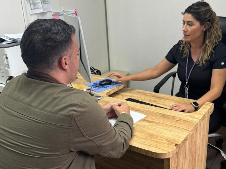 Consultorio médico. Doctora atiende a hombre que asiste a consulta sobre salud reproductiva.