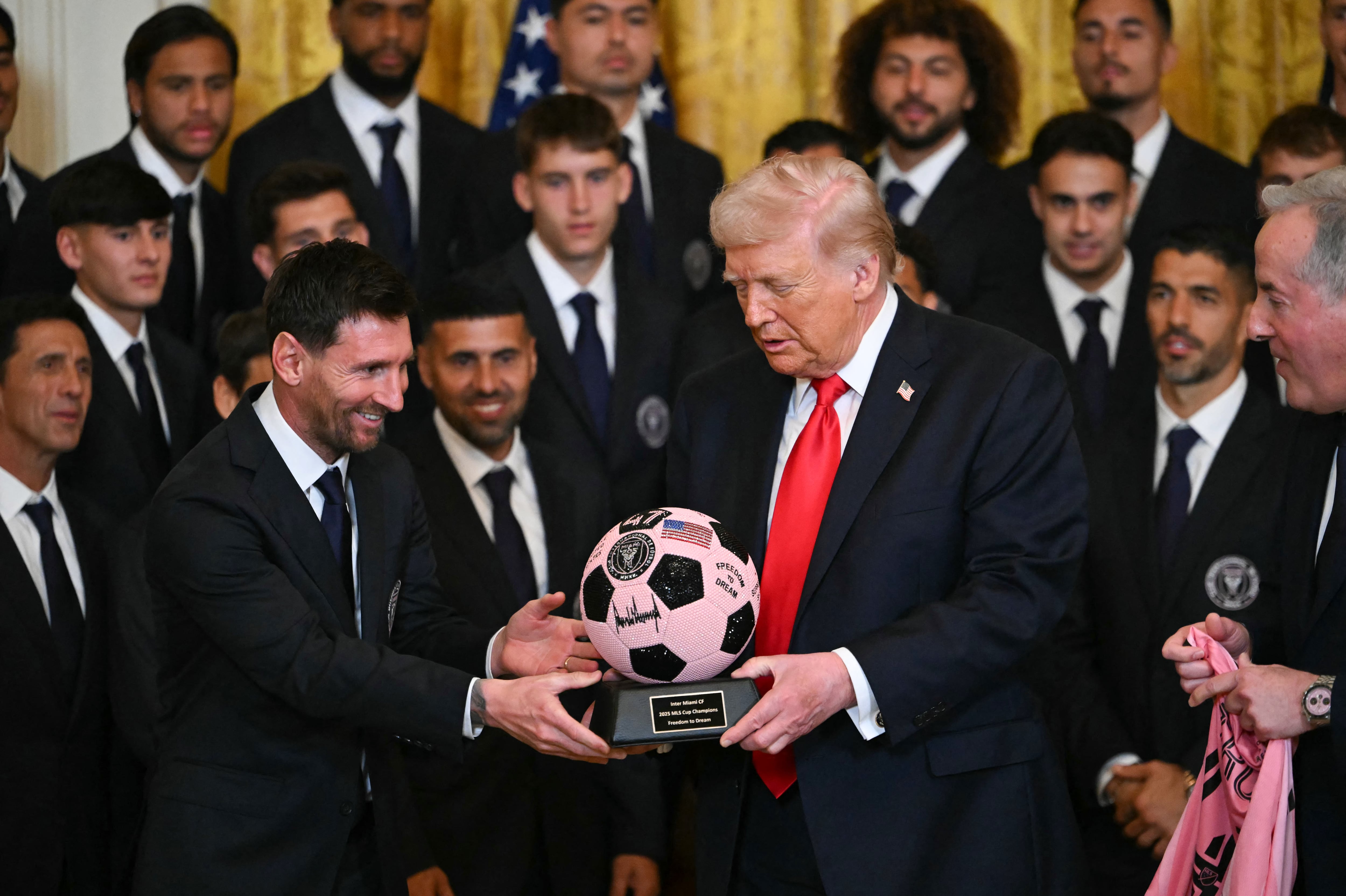 La estrella argentina Lionel Messi le entrega un balón al presidente de Estados Unidos Donald Trump durante un evento con el Inter Miami en la Casa Blanca.