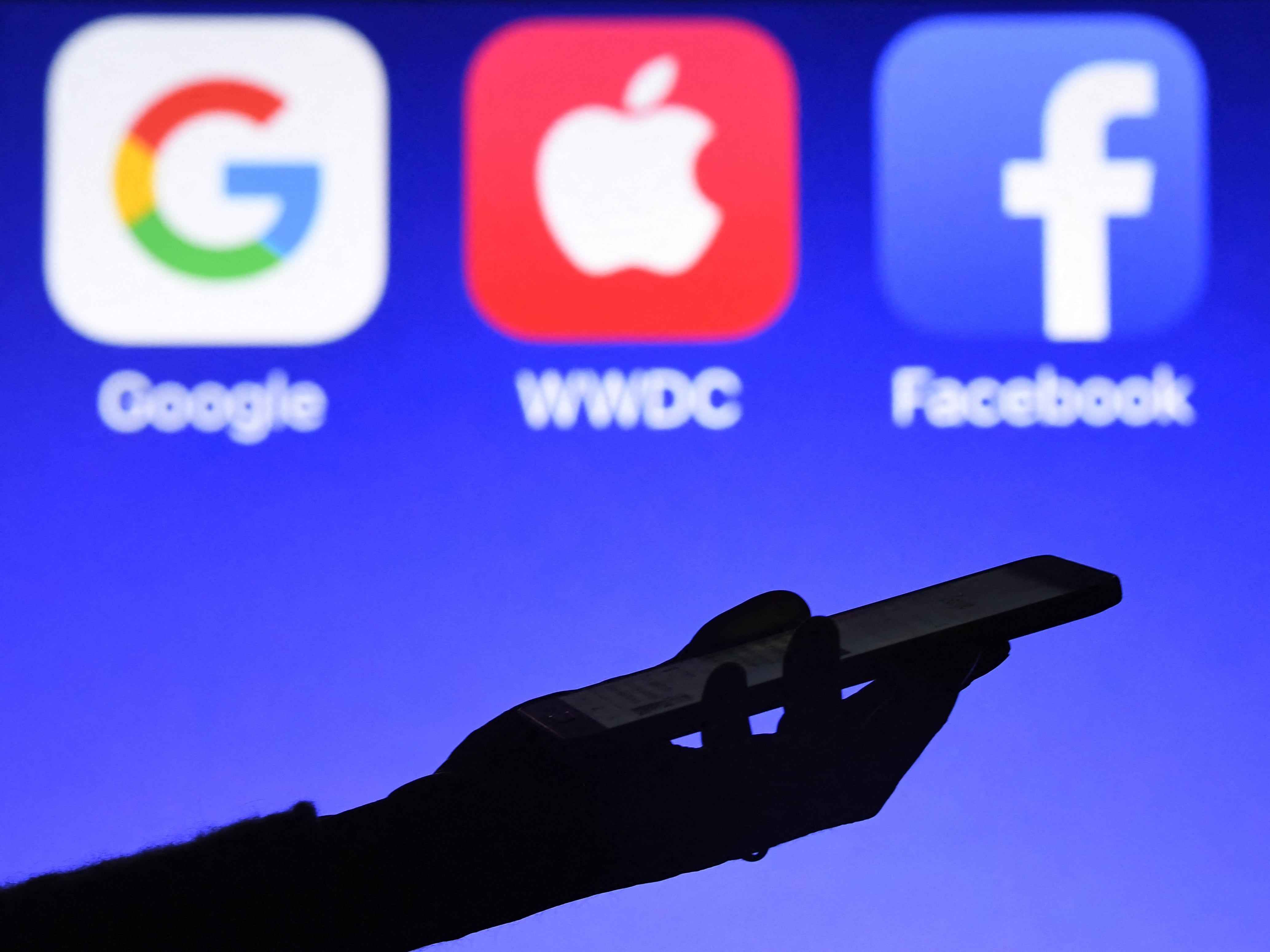 Esta fotografía, tomada el 28 de setiembre de 2017, muestra un teléfono inteligente siendo operado frente a los logotipos de GAFA (acrónimo de los gigantes de la web Google, Apple, Facebook y Amazon) como fondo en Hédé-Bazouges, al oeste de Francia. (Foto: Damien MEYER / AFP)