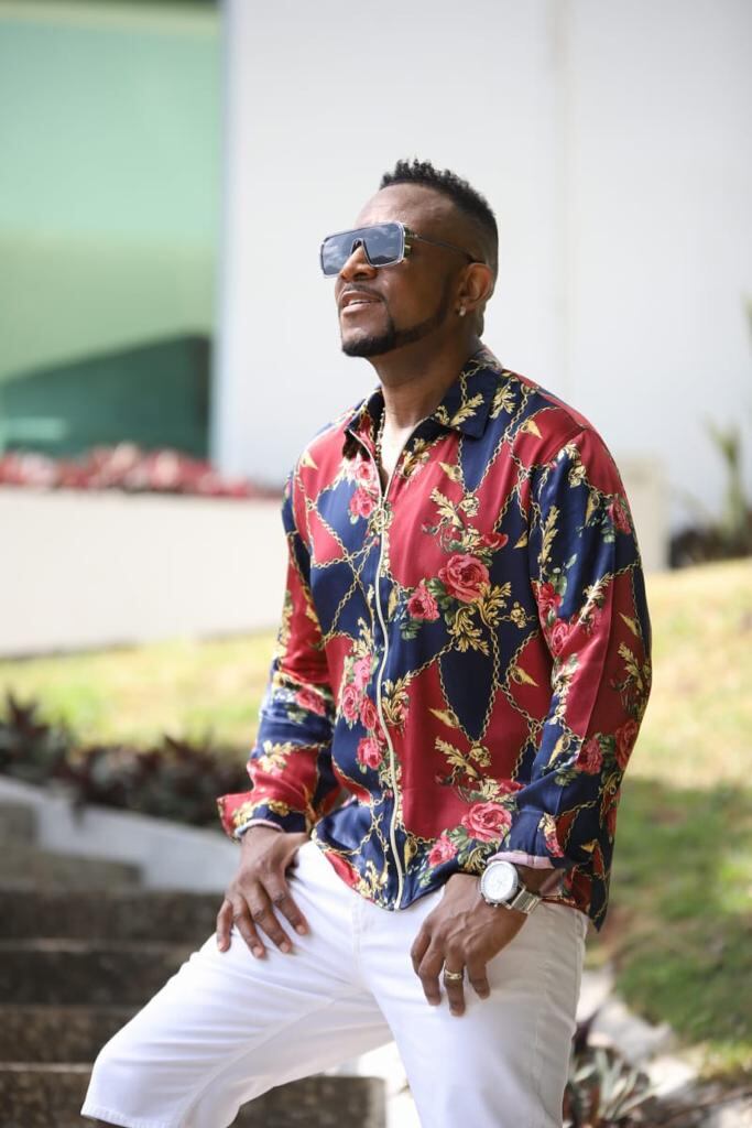 Foto del cantante panameño Aldo Ranks usa lentes, camisa de colores y pantalón blanco.