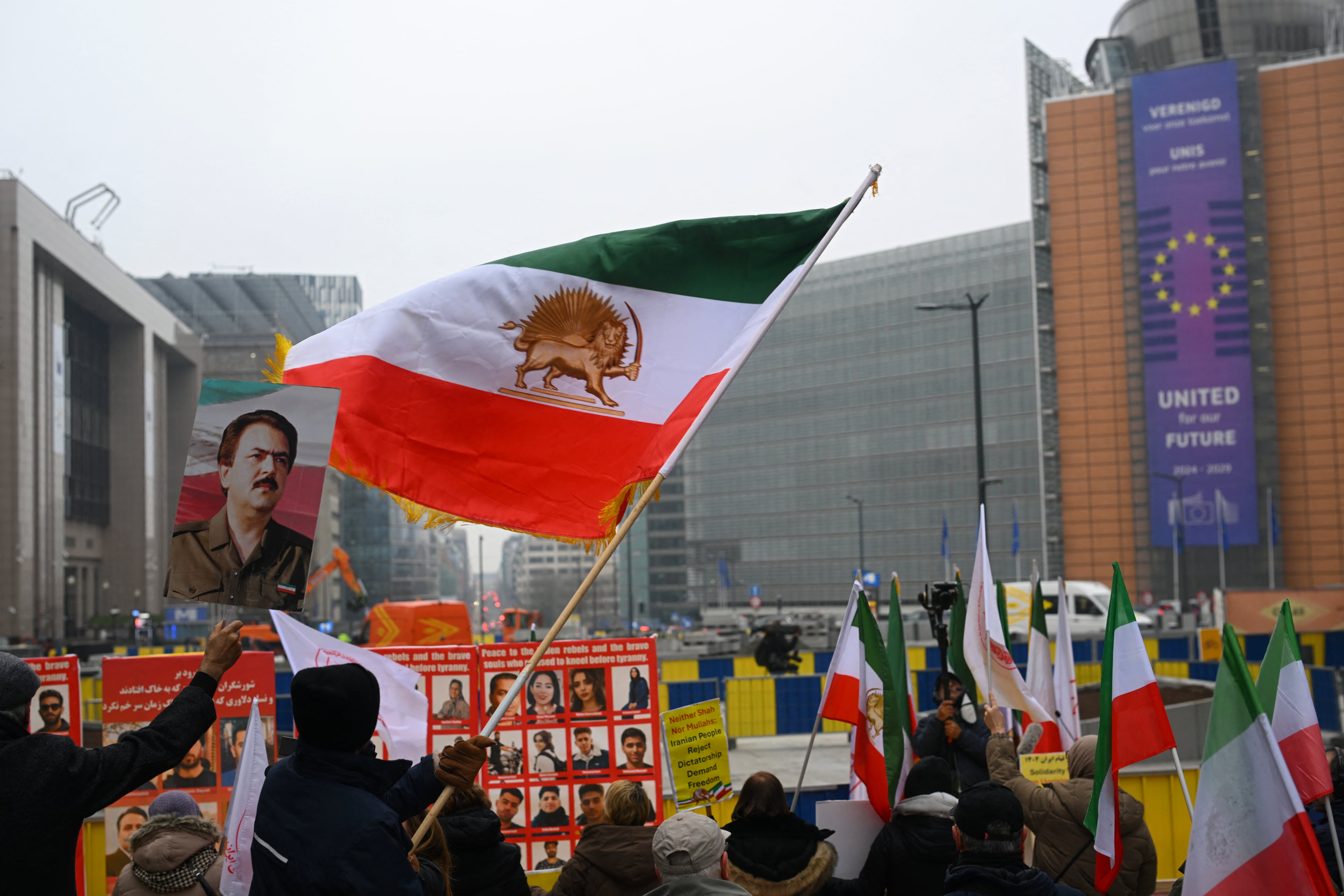 Supporters of the National Council of Resistance of Iran wave Iranian flags as they take part in a demonstration in support of the Iranian people in Brussels on January 29, 2026. (Photo by Nicolas TUCAT / AFP)