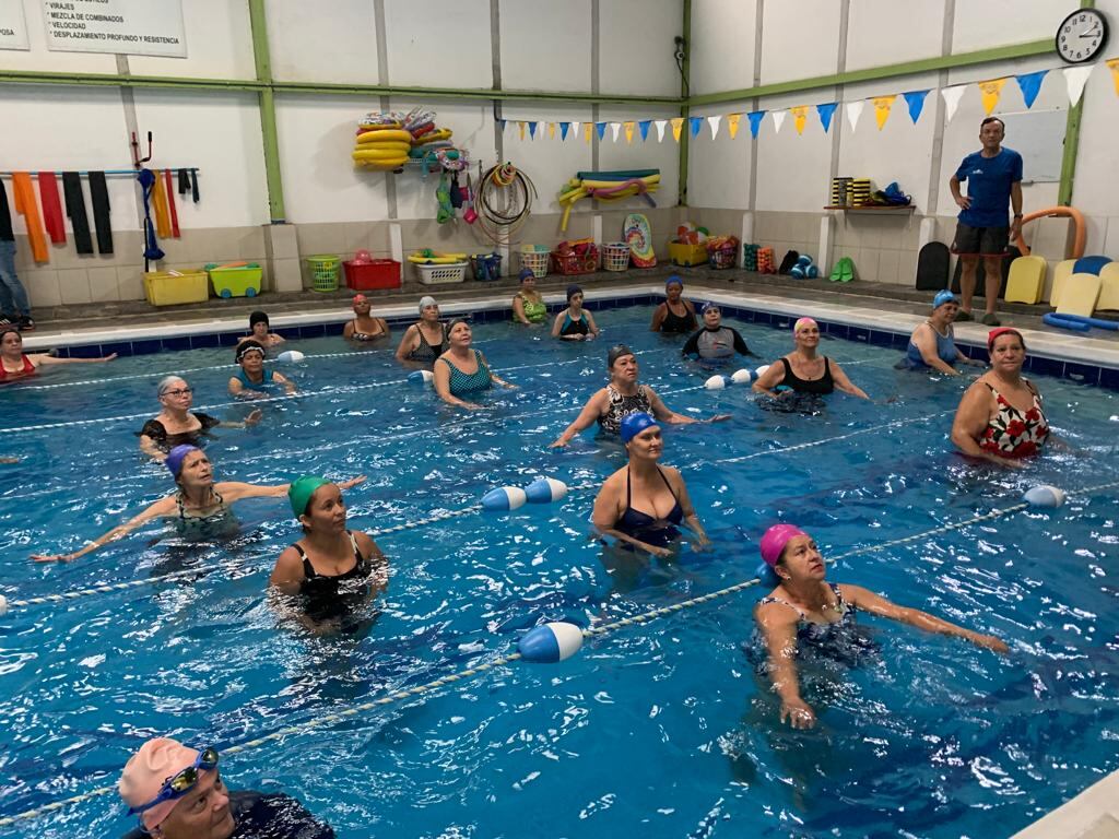 Personas en una piscina haciendo acuaeróbicos.