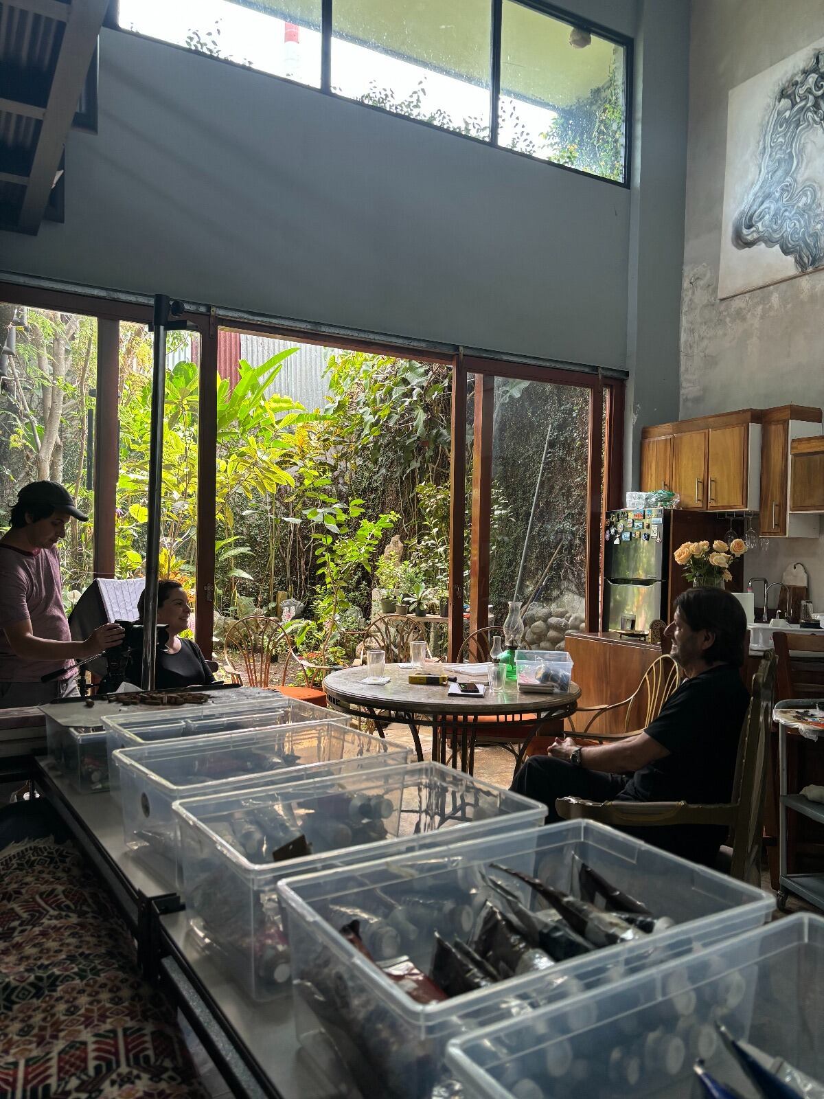 El pintor Miguel Hernández atiende una entrevista de la periodista Daniela Fernández en su taller.