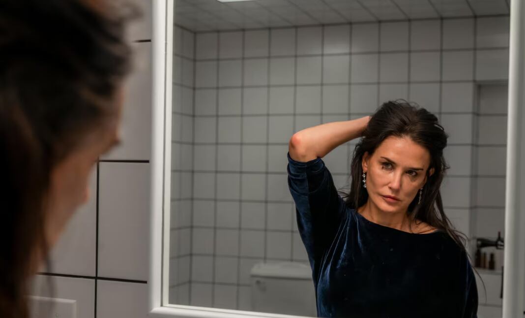 Demi Moore en su papel en la película 'La sustancia', se ve frente a un espejo.