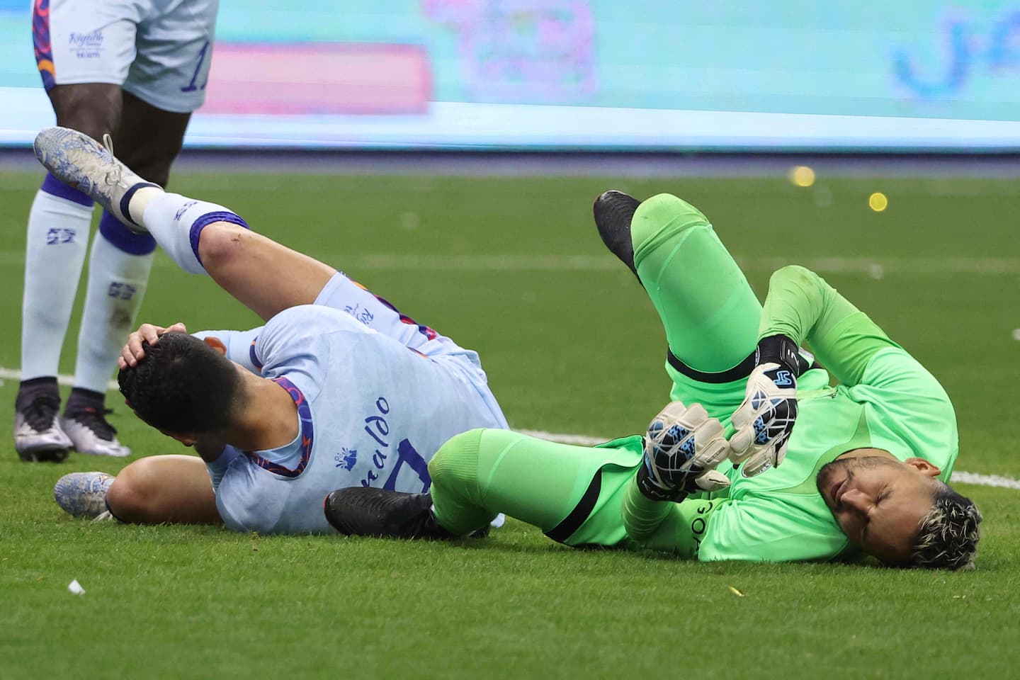 Riyadh All-Star's Portuguese forward Cristiano Ronaldo (L), and Paris Saint-Germain's Costa Rican goalkeeper Keylor Navas (R) react after colliding during the Riyadh Season Cup football match between the Riyadh All-Stars and Paris Saint-Germain at the King Fahd Stadium in Riyadh on January 19, 2023. (Photo by Giuseppe CACACE / AFP)