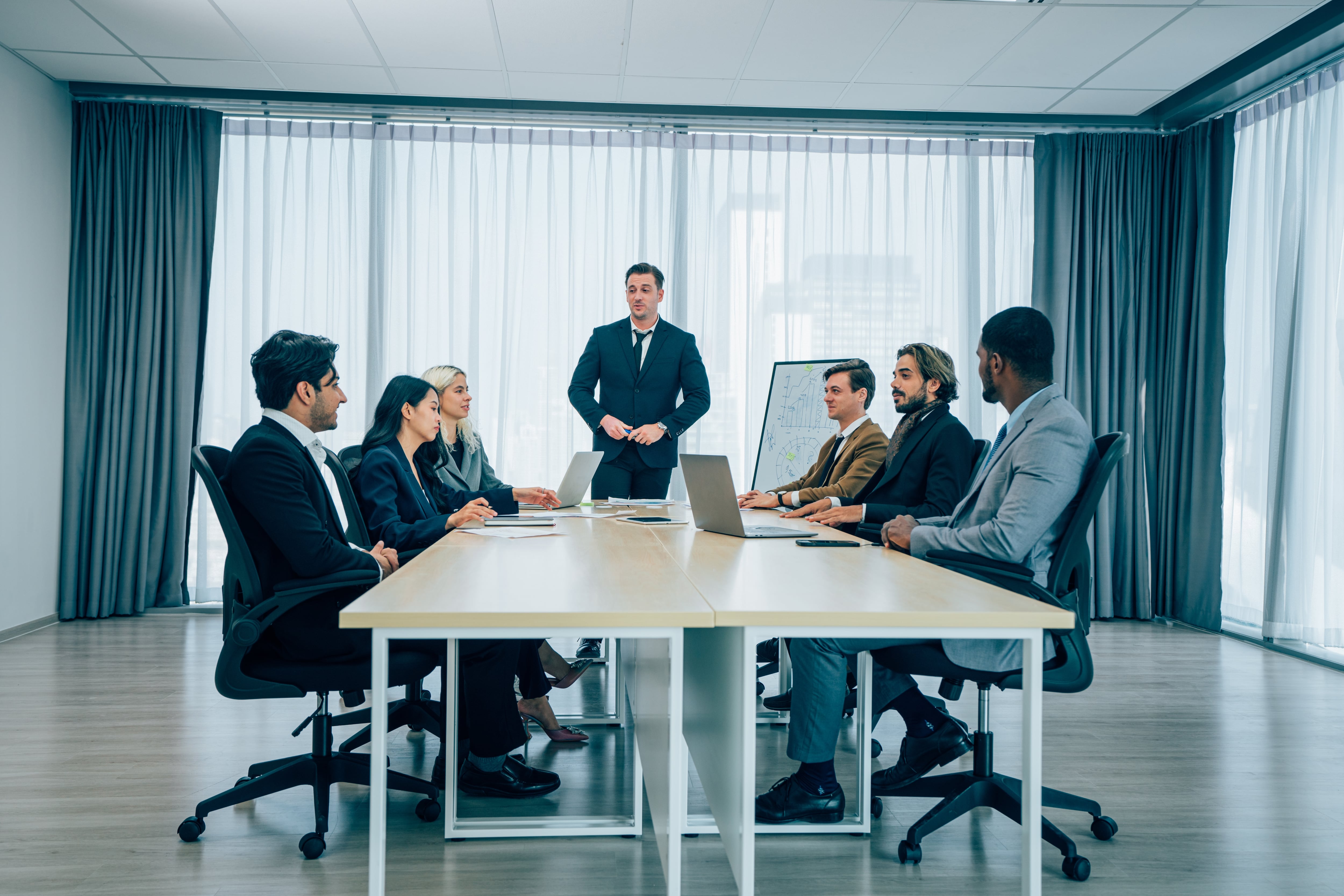 Funcionarios en trajes formales, reunidos en sala de reuniones, ambientes de oficina