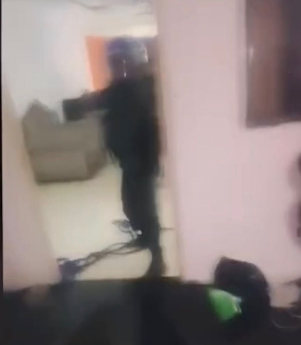 Este sería uno de los policías, con casco azul y apuntando con un arma de fuego, que supuestamente ingresó de manera ilegal a la vivienda en Purral. La imagen corresponde a una captura de la videollamada.